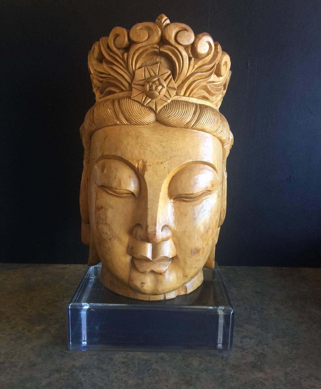 A very cool and impressive hand carved wooden Buddha head on a large solid acrylic base. There are a couple of small wood gouges on the piece (see pictures), but they only add to the charm and elegance of the sculpture.