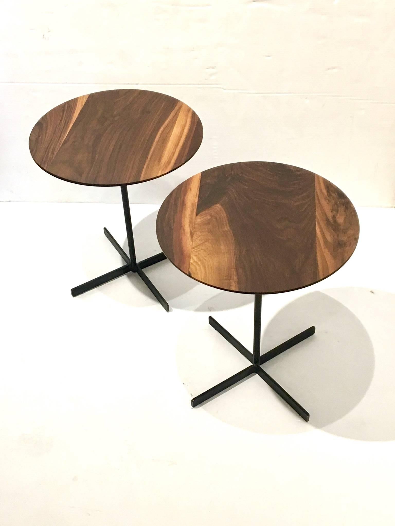 Simple elegant pair of solid beveled walnut round top, Cocktail Tables with solid black painted iron bases, in the style of Allan Gould.