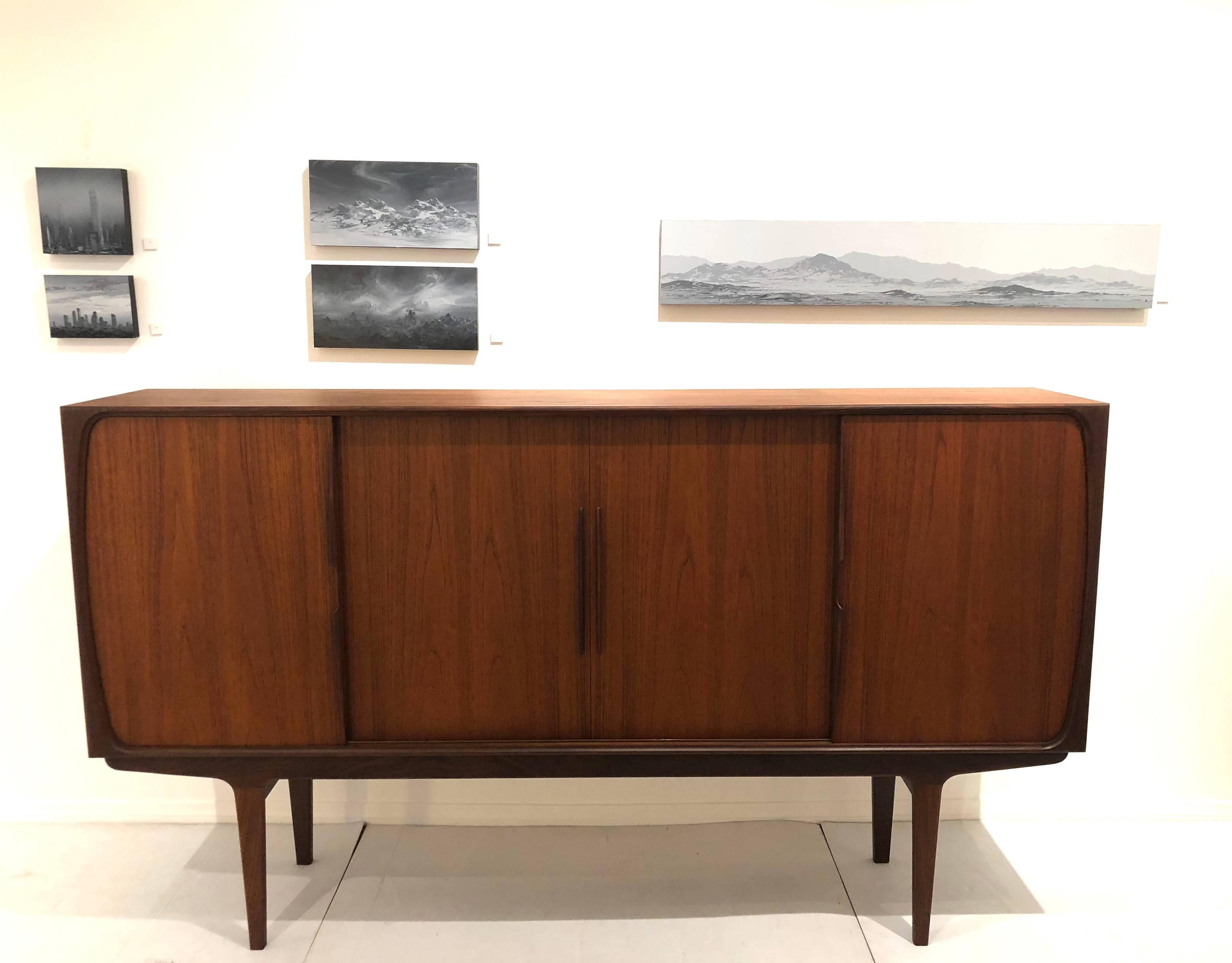 Beautiful large and impressive teak credenza with zebra wood interior, and mirror back with detail, circa 1950s freshly restored in great condition, tons of storage, one of a kind piece beautiful handles and grain on the wood, sliding doors and