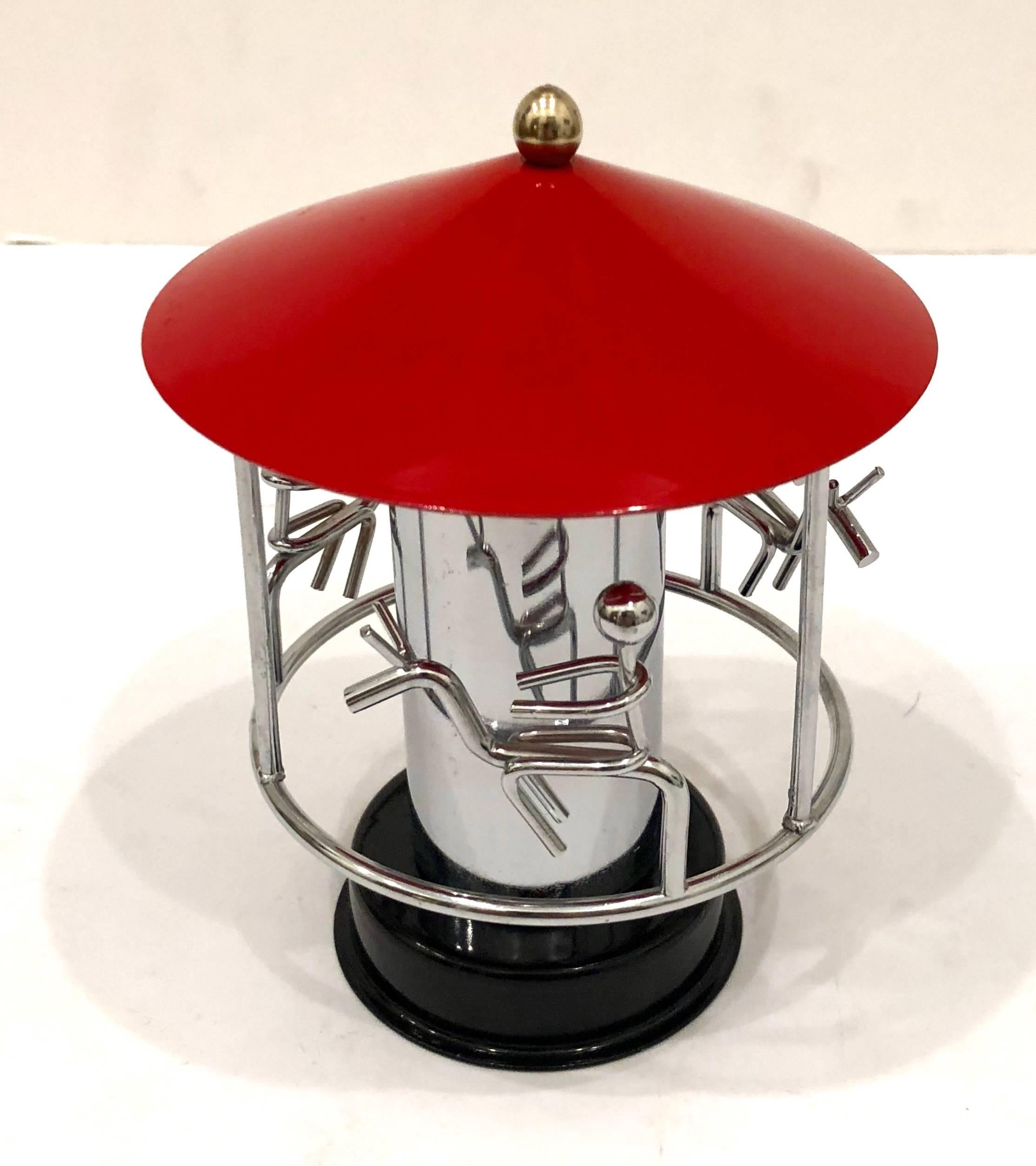 1970's manually rotating carousel sculpture with red enameled top, and brass accents, and chrome. A simple modern design. 