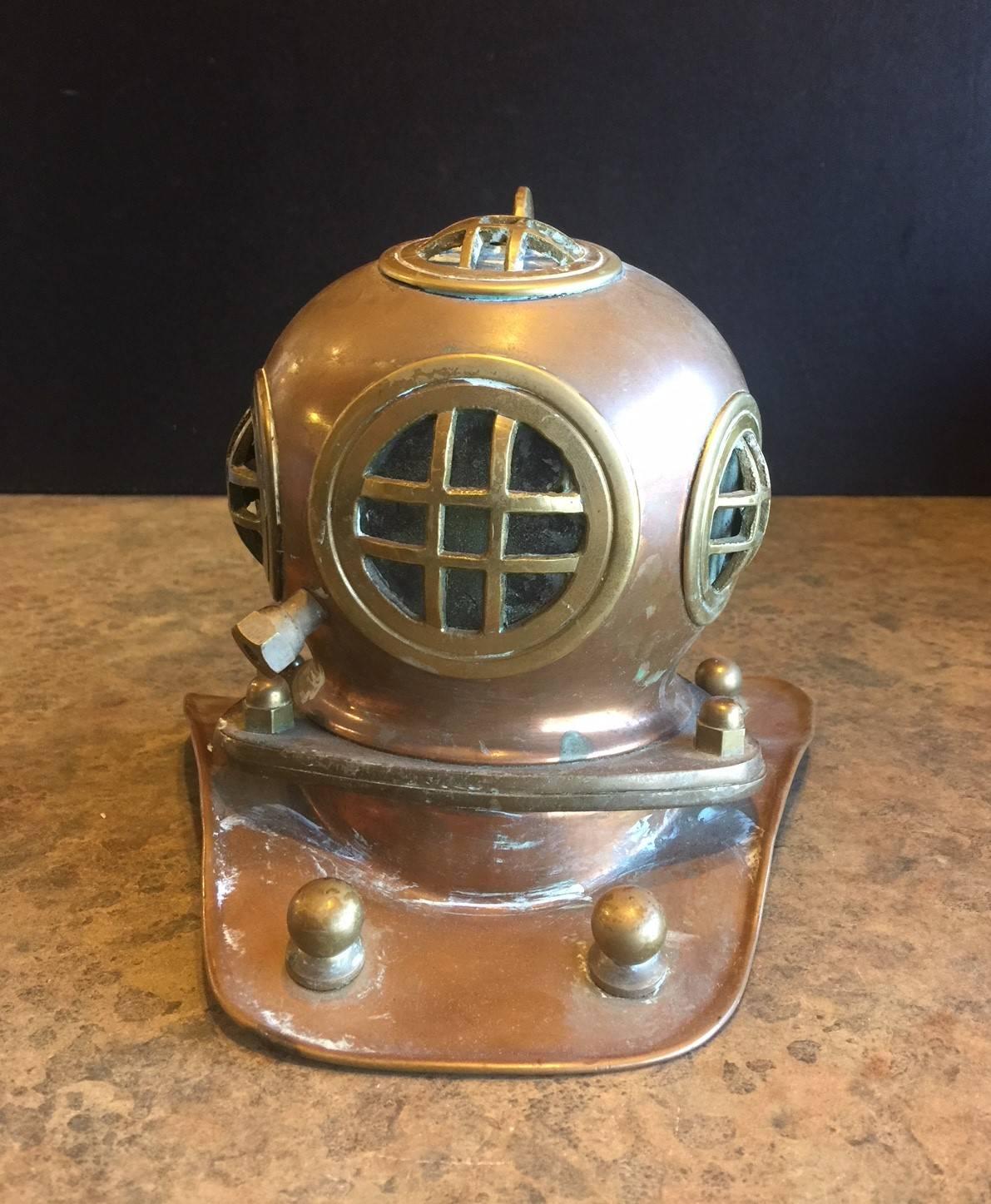 Very cool miniature vintage diver's helmet made of copper, brass and glass, circa 1950's.  The piece is heavy and has a great patina and would make a great decor item for an office, den or nautical collector.