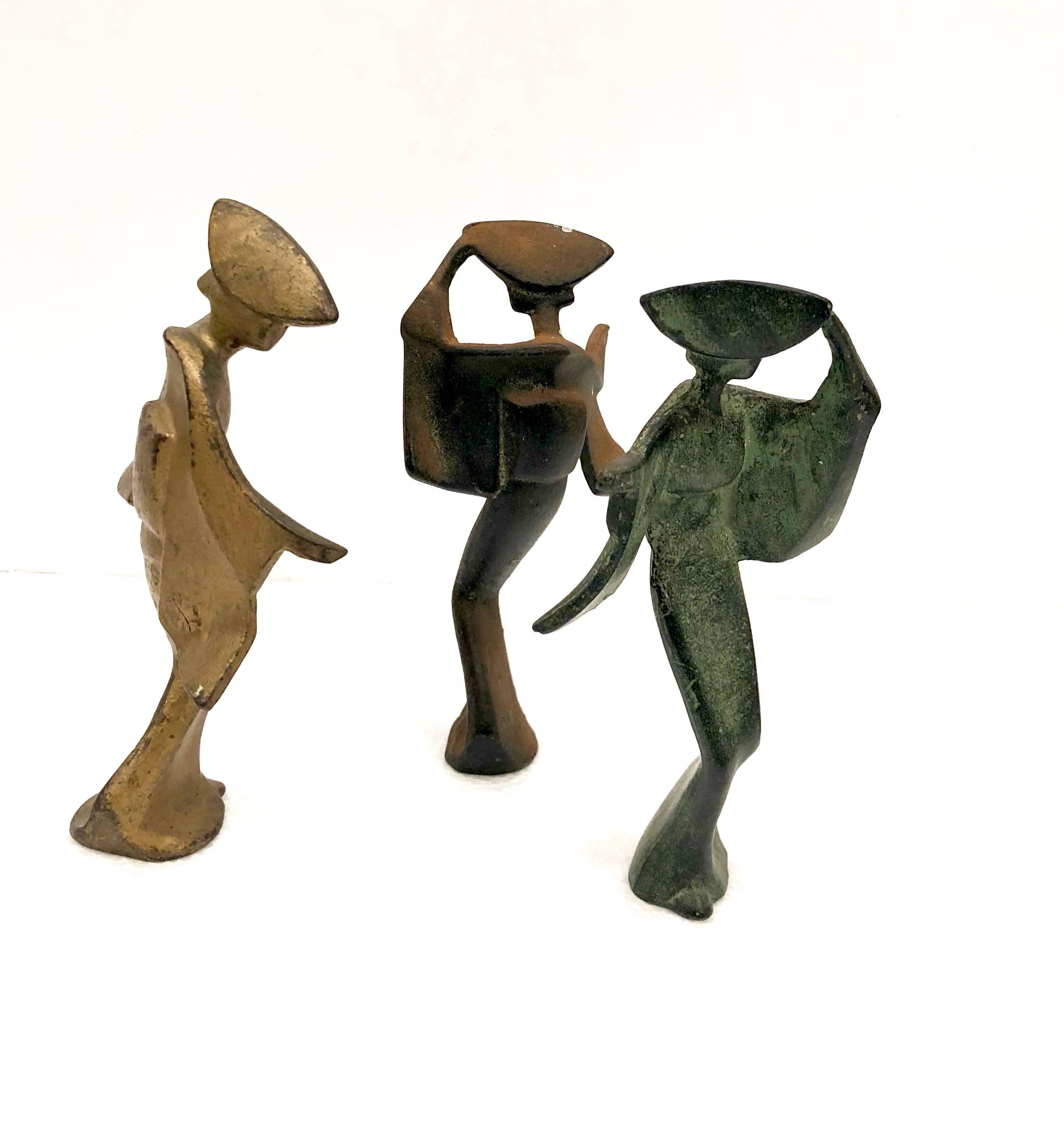 Nice set of three patinated metals Japanese geisha figurines, circa 1950s. The pieces are heavy and solid and have a real nice dark patina; in a bronze, copper and black finish they would make a great Mid-Century Modern accent in any space!