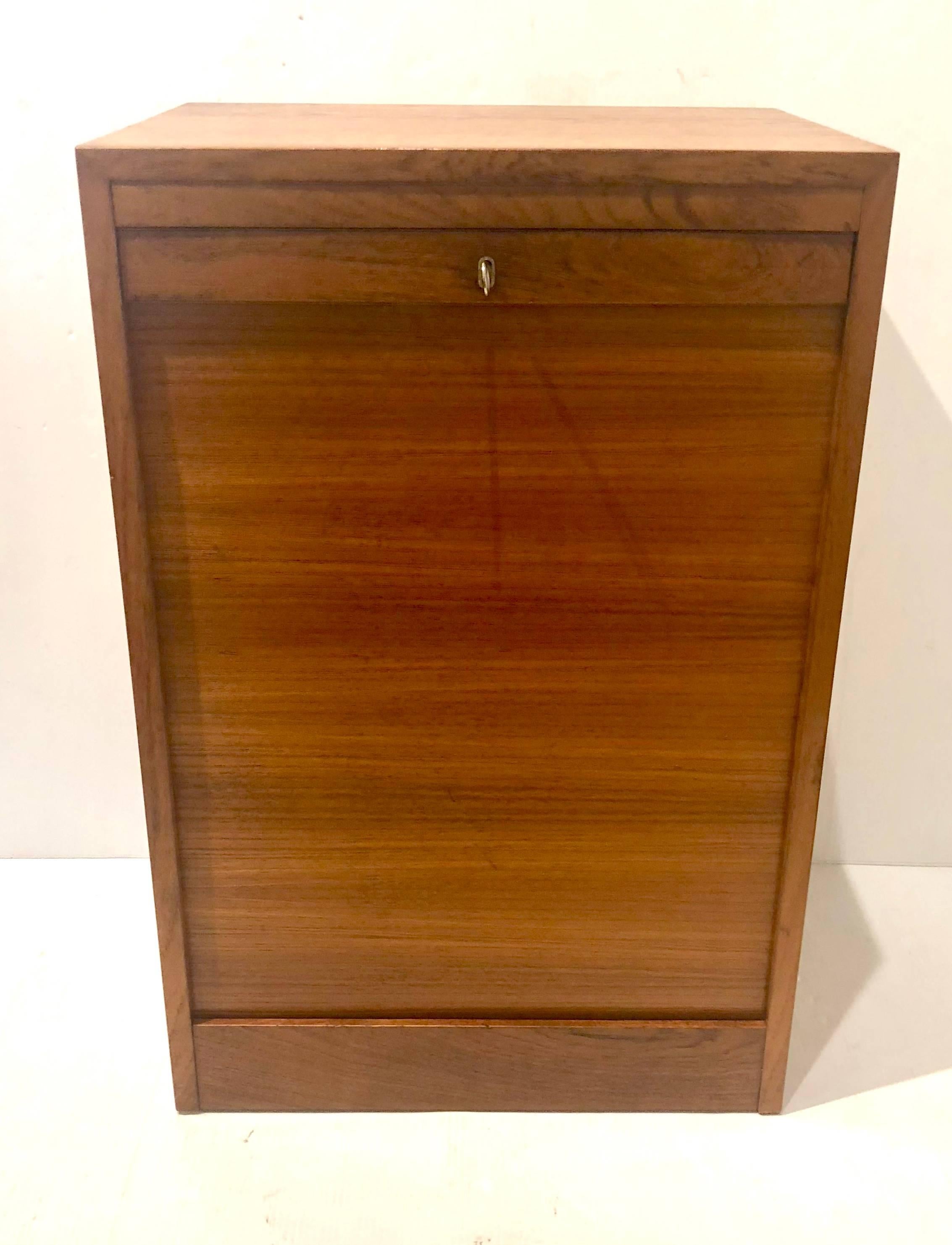 Versatile file cabinet or artist cabinet in original finish teak with lock key, and tambour door, drawers finish in birch wood, hard to find piece, each drawer. Measures: 12