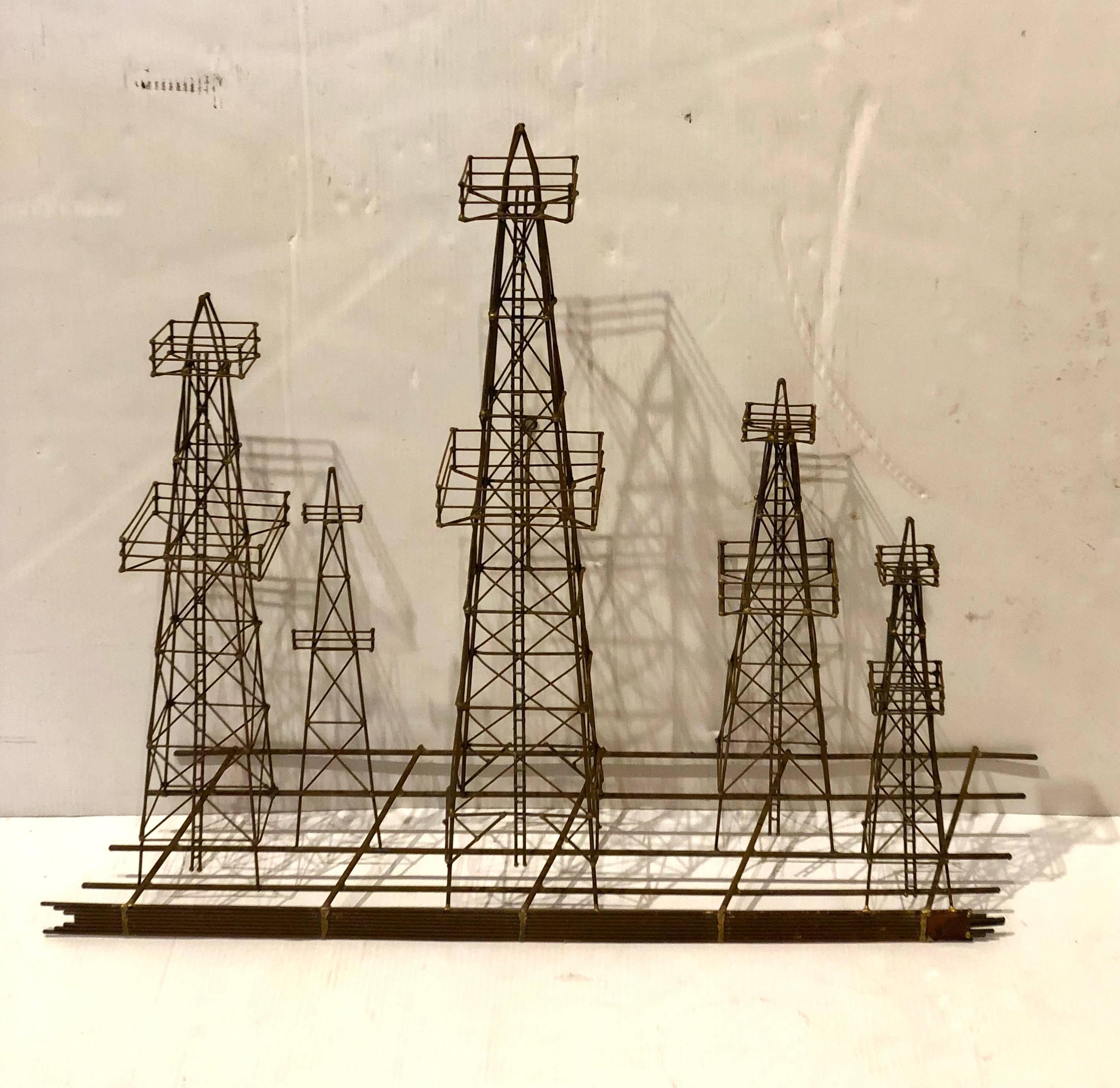 Patinated metal tri dimensional wall sculpture in a rusted finish, with brass weldings oil towers field, circa 1970s in the style of Curtis Jere.