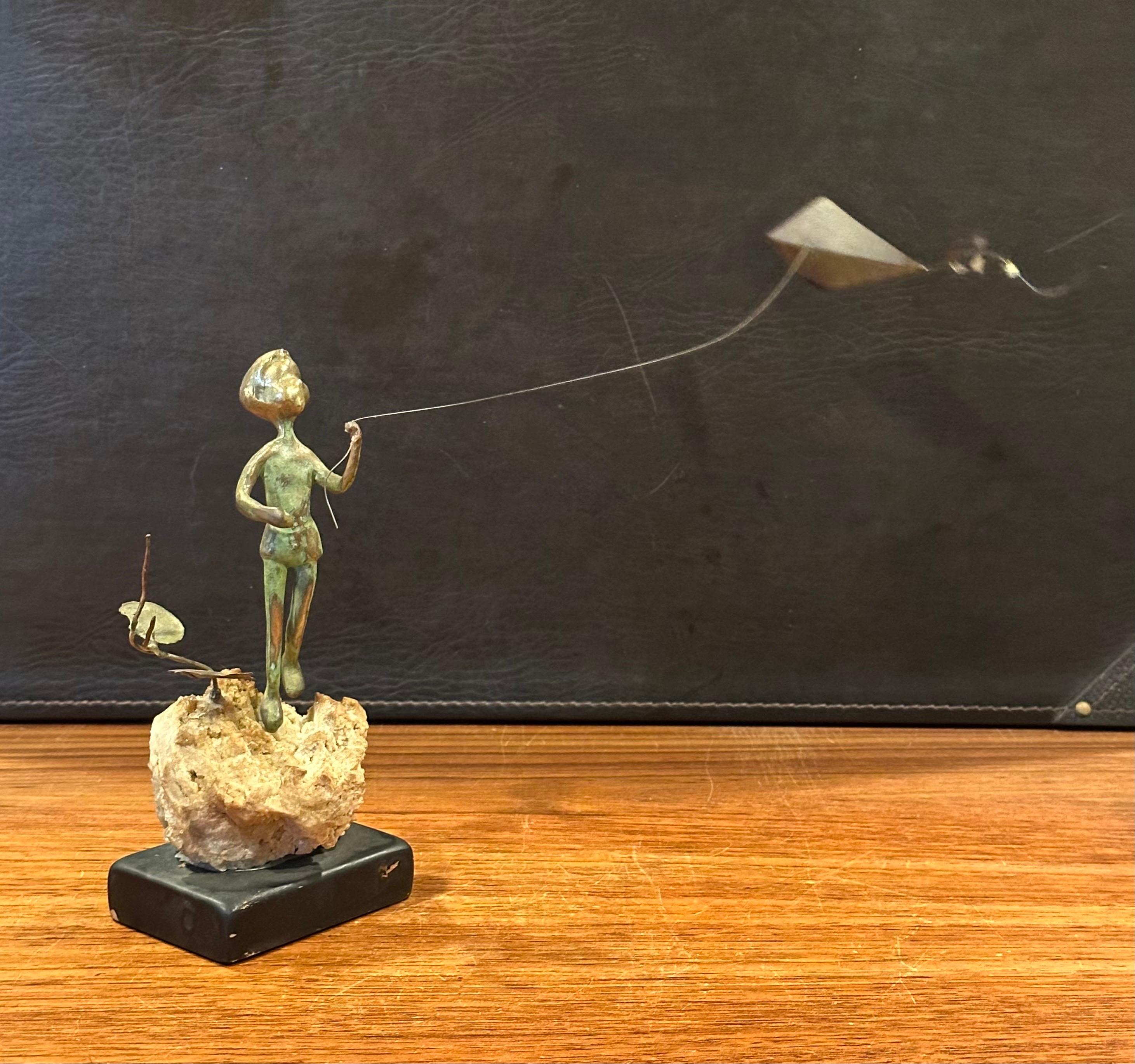 Niño volando una cometa Escultura de bronce sobre roca volcánica de Malcolm Moran en Bueno estado para la venta en San Diego, CA