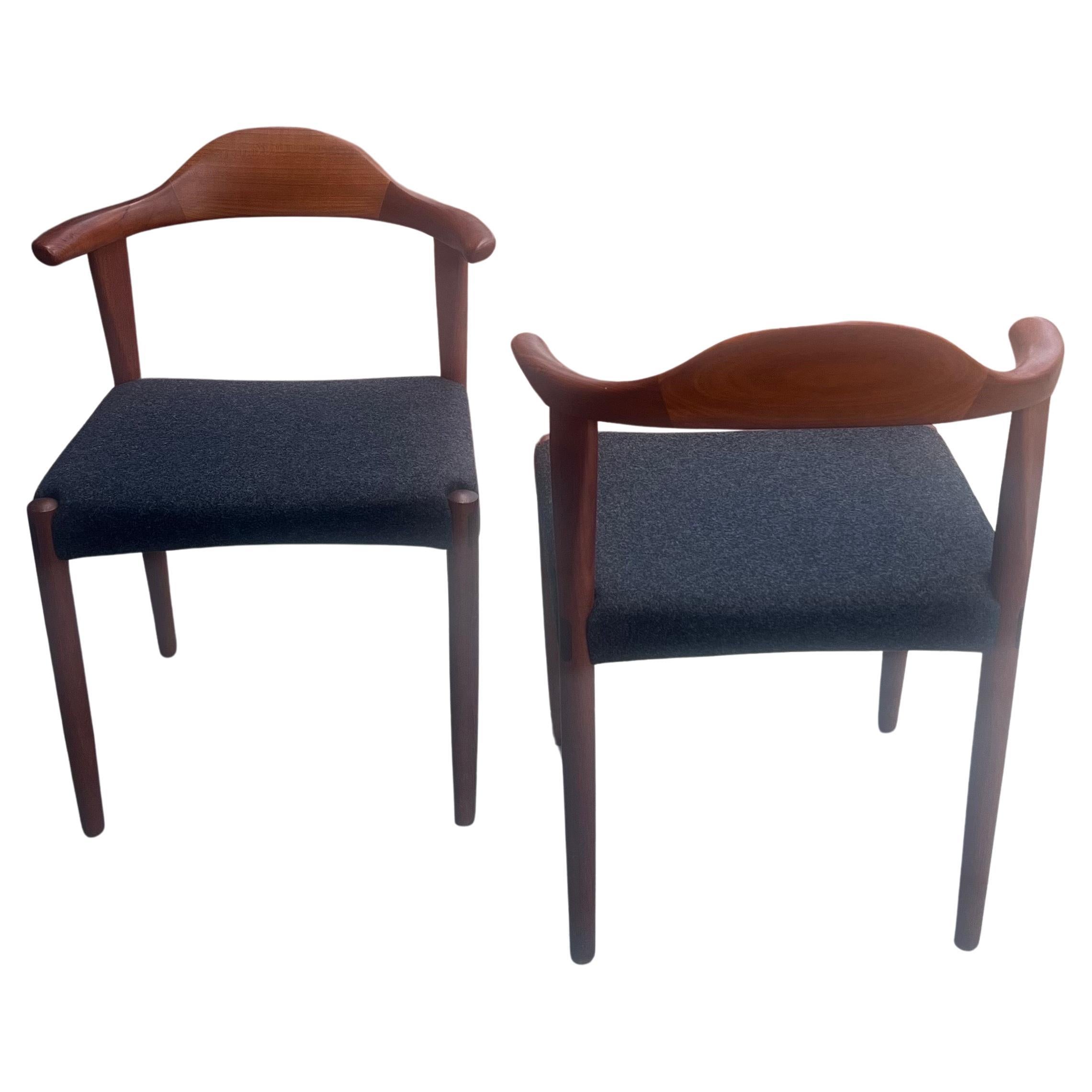 Immerse yourself in the timeless elegance of mid-century Danish design with this exquisite pair of 'Bull Horn' chairs crafted by Harry Østergaard for Randers Møbelfabrik in the 1950s. These chairs stand as a testament to the unparalleled