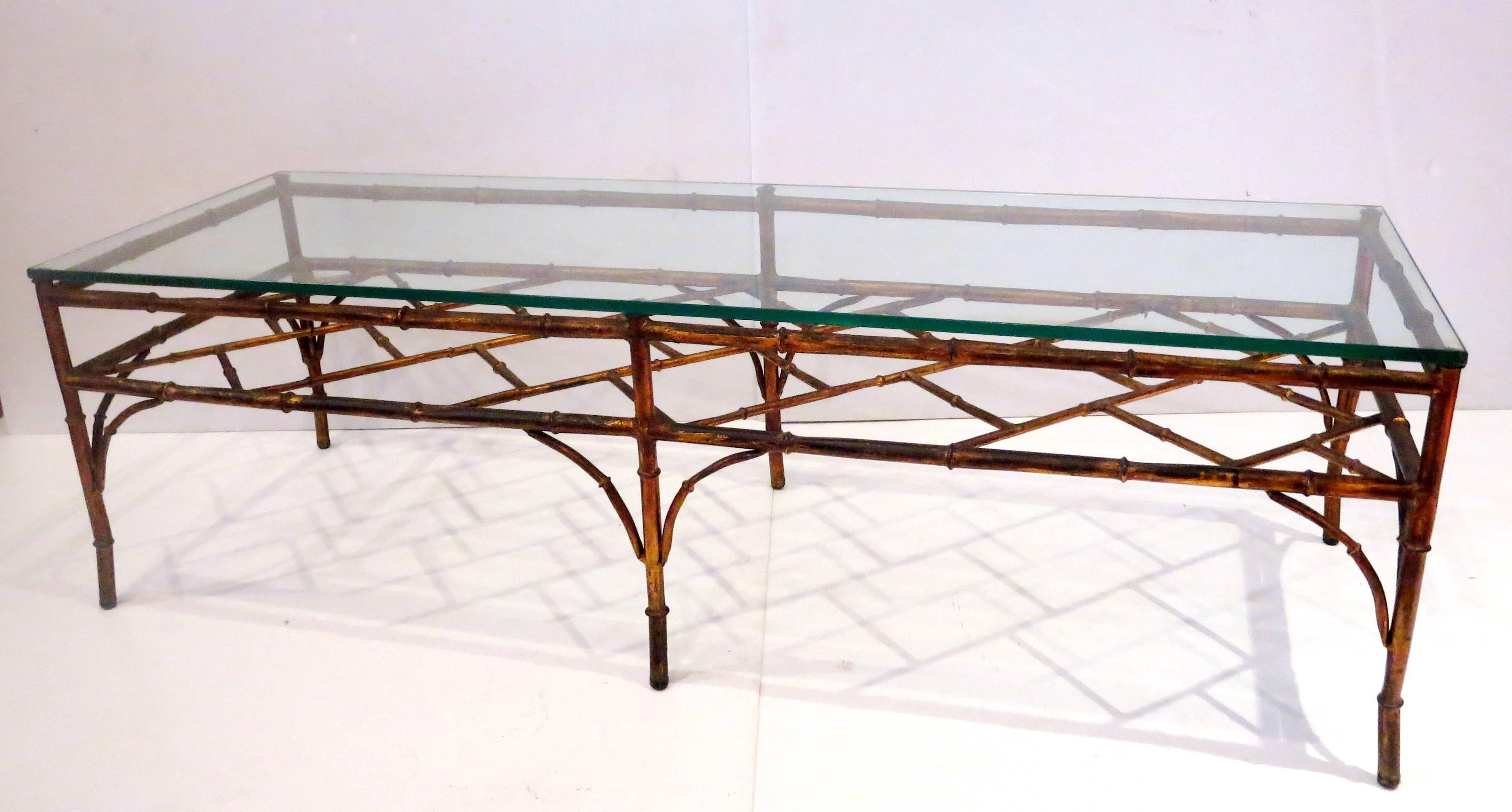 Elegant gold gilt tubular faux bamboo metal frame coffee table with thick glass top. Excellent condition, solid and sturdy. 