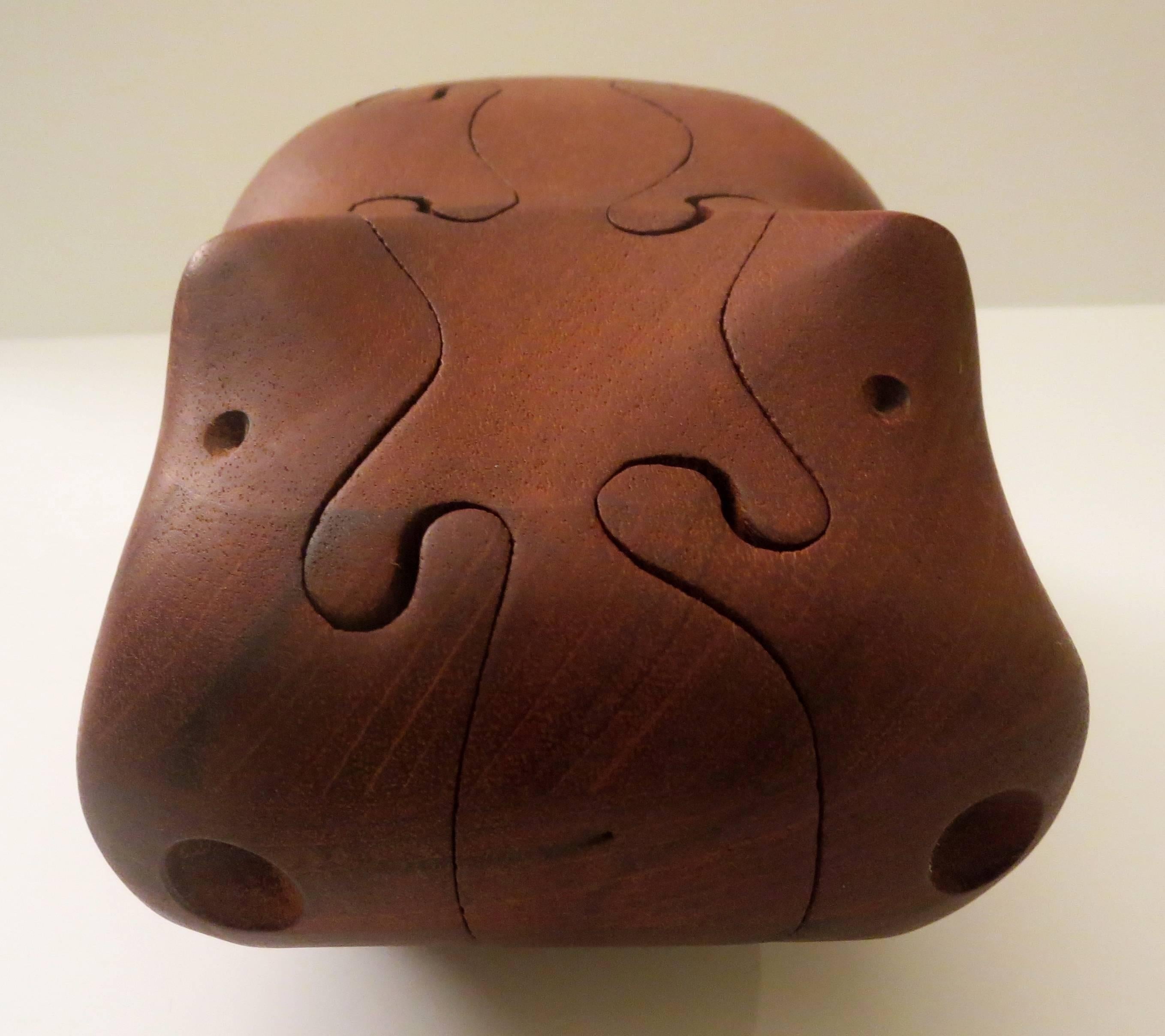 Incredible craftsmanship on this solid walnut hippo puzzle designed and hand crafted by artist Deborah Bump. Fully signed on bottom. Circa 1970s.


