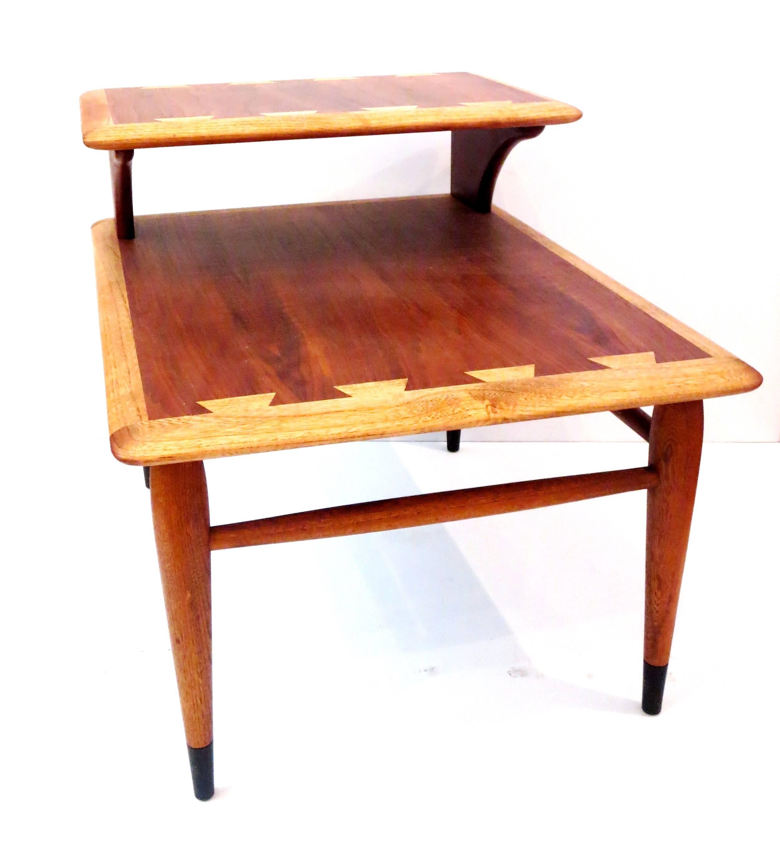 Beautiful craftsmanship on this 1950s , american modern walnut inlaid step end end table, solid tapered legs with black lacquered end tips , and beech wood combination, the table its in great condition , totally refinished . great between 2 club