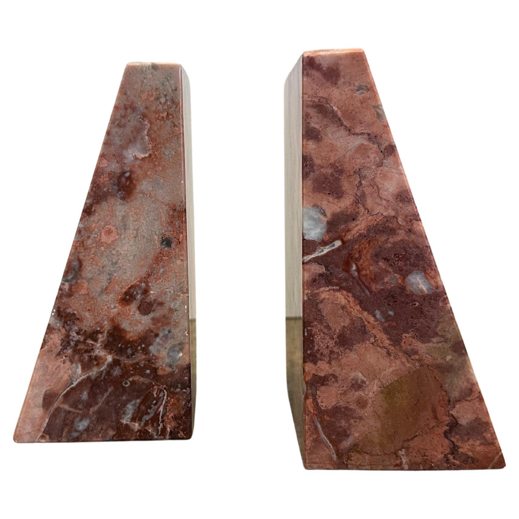Bellissima e rara coppia di fermalibri postmoderni in marmo rosa. Questi grandi pezzi di marmo sono tanto affascinanti quanto imponenti. Le venature che si sviluppano sul marmo rosa con sfumature rossastre, grigie e beige ondeggiano mentre la forma