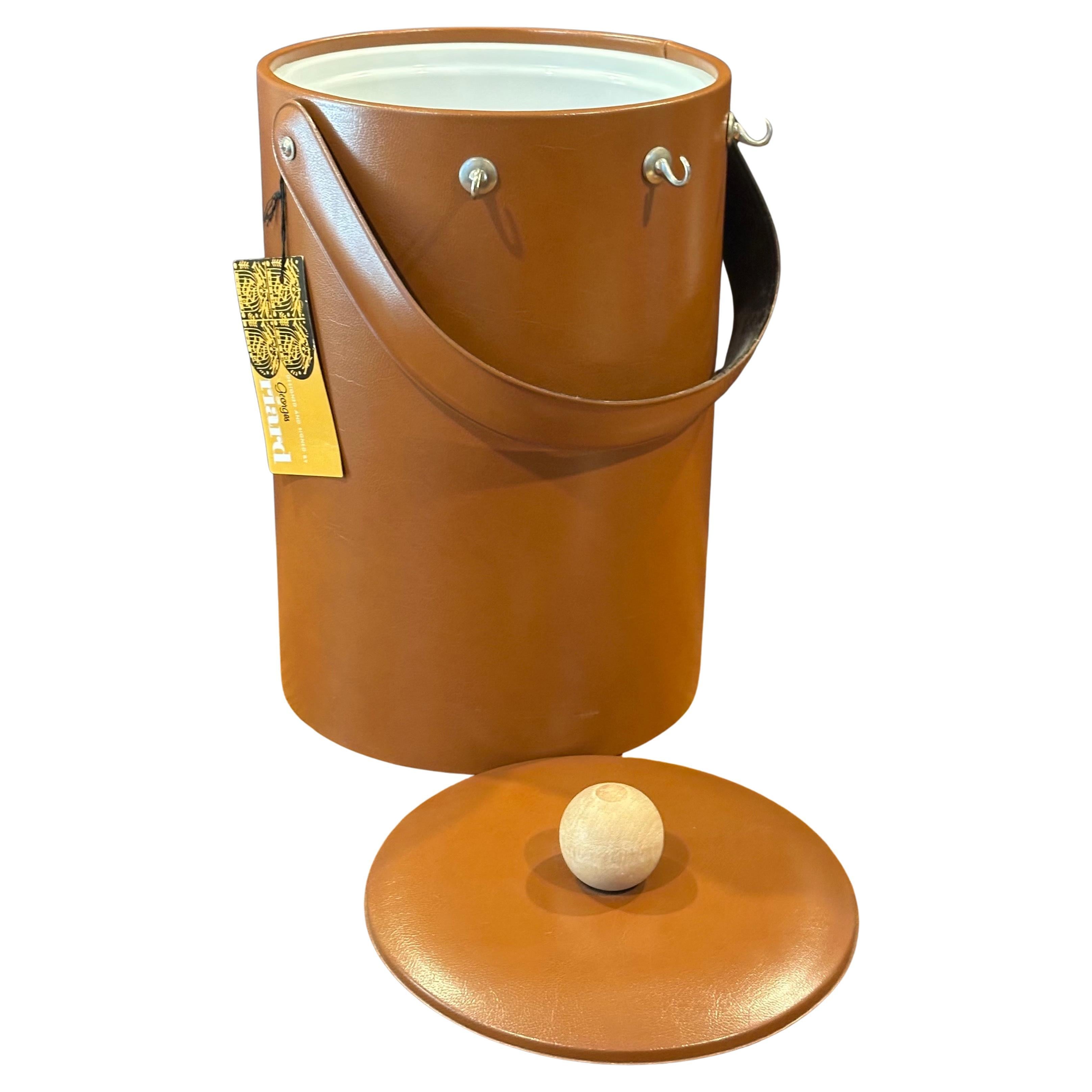 A very nice mid-century lidded ice bucket with three bar tools by Georges Briard, circa 1970s. The piece is in brand new never used condition and maintains its original hang tag.  The bucket measures 8