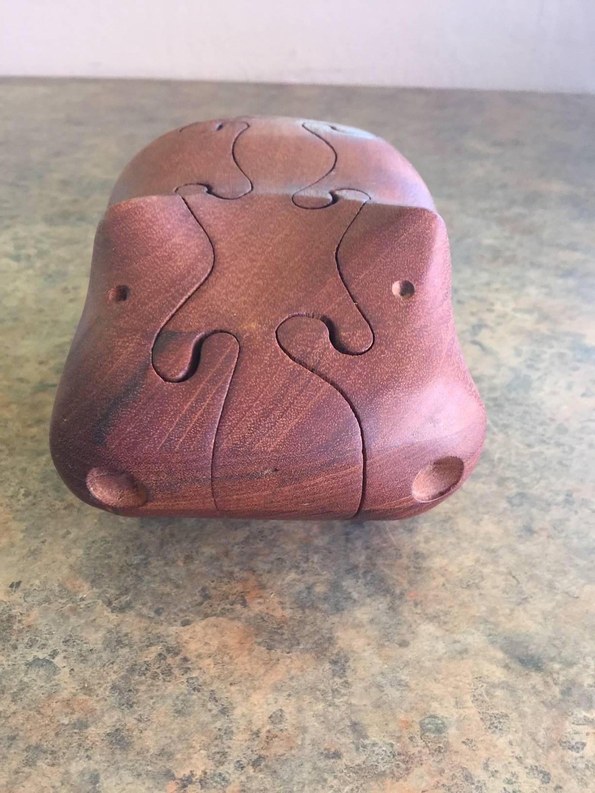 A very cool and unique vintage hippo puzzle / sculpture cut from teak wood and signed by noted Mid-Century artist Deborah D. Bump.