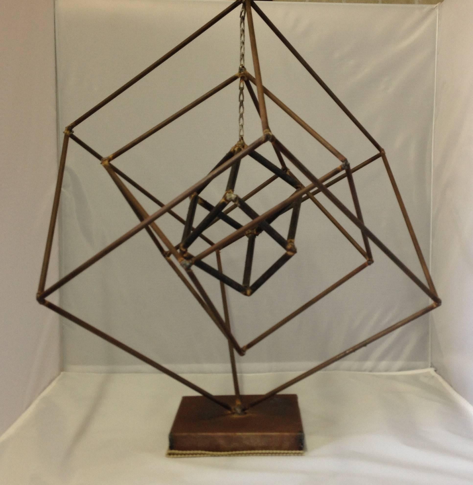 Very unique piece by American metal sculptor, Frank Cota. Three free-form iron cubes on a signed base. The two smaller cubes hang by a chain and can rotate. Classic Brutalist piece with a rough finish on the iron.  #91