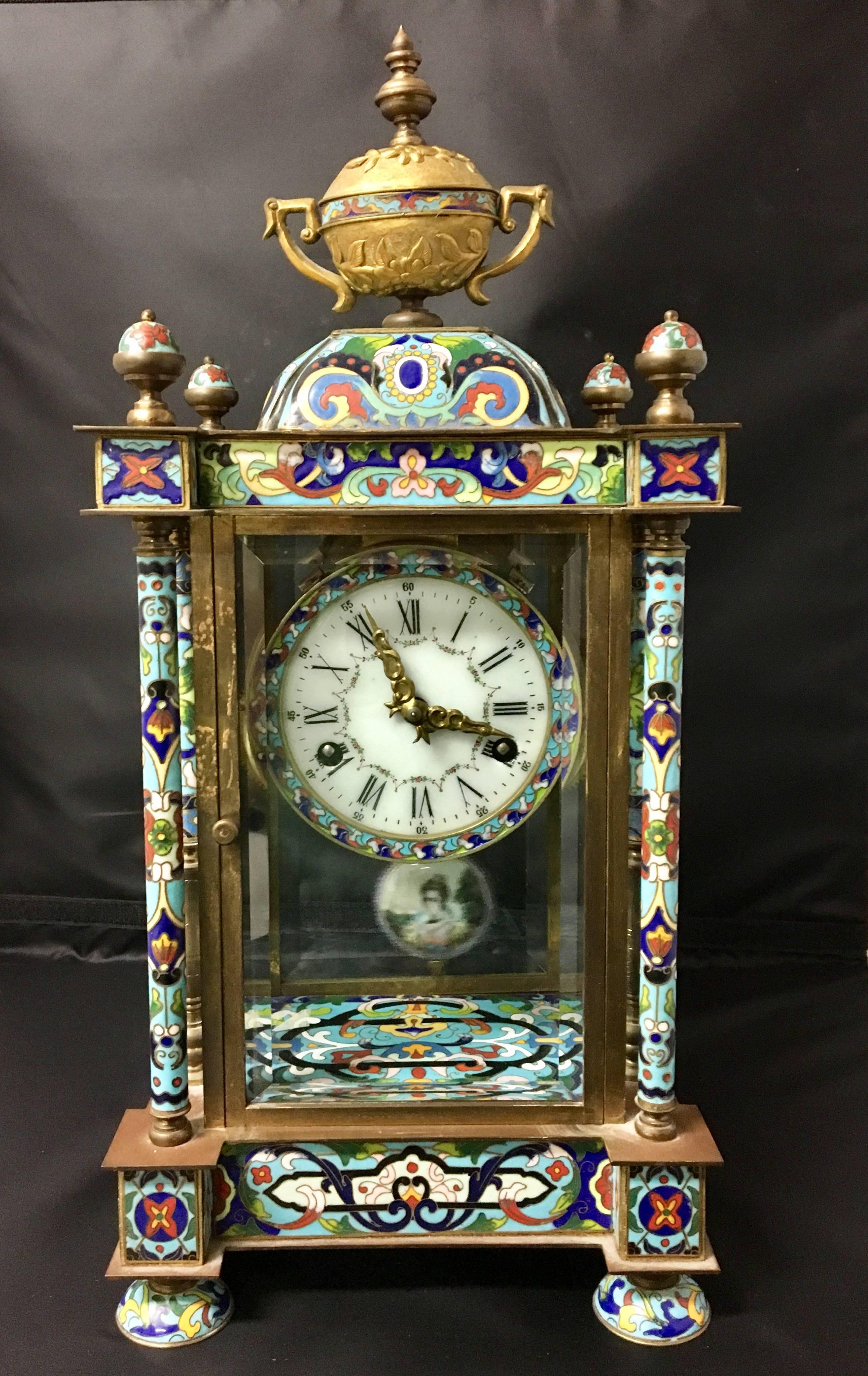 Massive Chinese style cloisonne or brass mantel clock enclosed in a four-sided beveled glass casing. Cameo face embedded in pendulum. Very nice working condition.