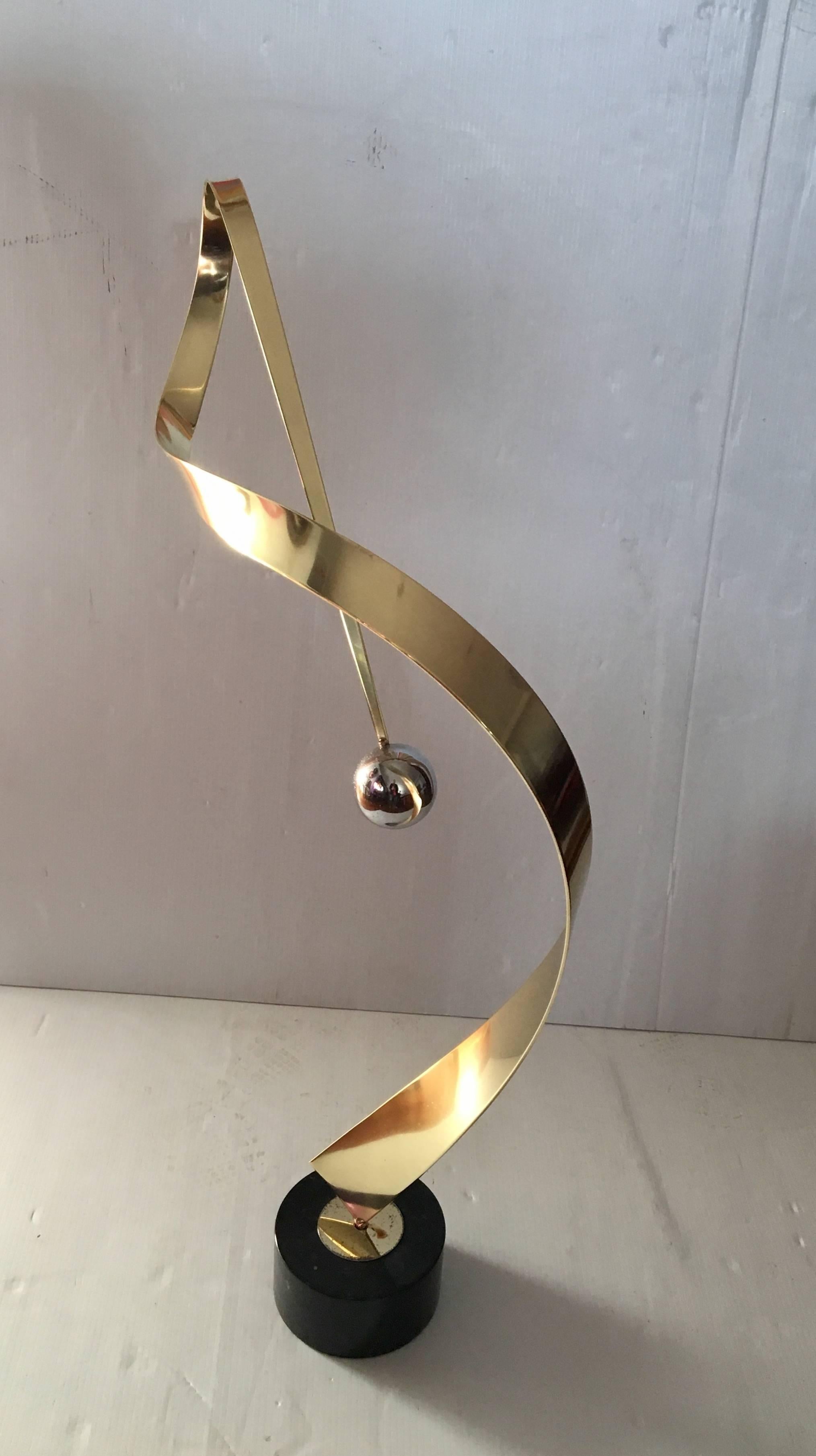 Beautiful abstract tall sculpture by Curtis Jere , Polished brass with a solid chrome ball sitting on a black marble base , the sculpture has been polished the brass ring on the bottom shows some wear due to age , its a great piece that will