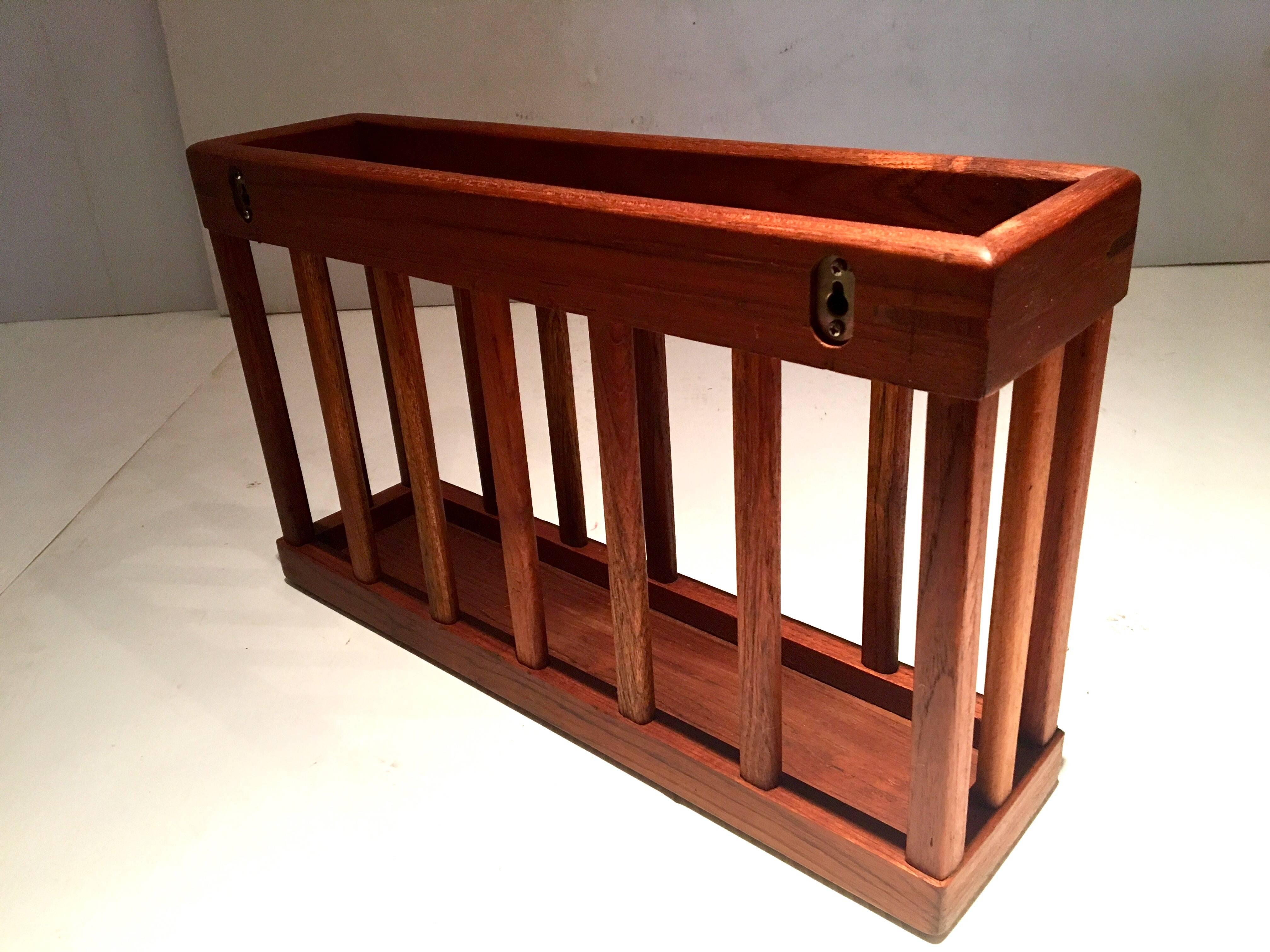 Nice craftsmanship on this solid teak magazine rack, circa 1970s it can be used on the floor, or wall-mounted has two holes where it can be hooked, its been freshly restored.