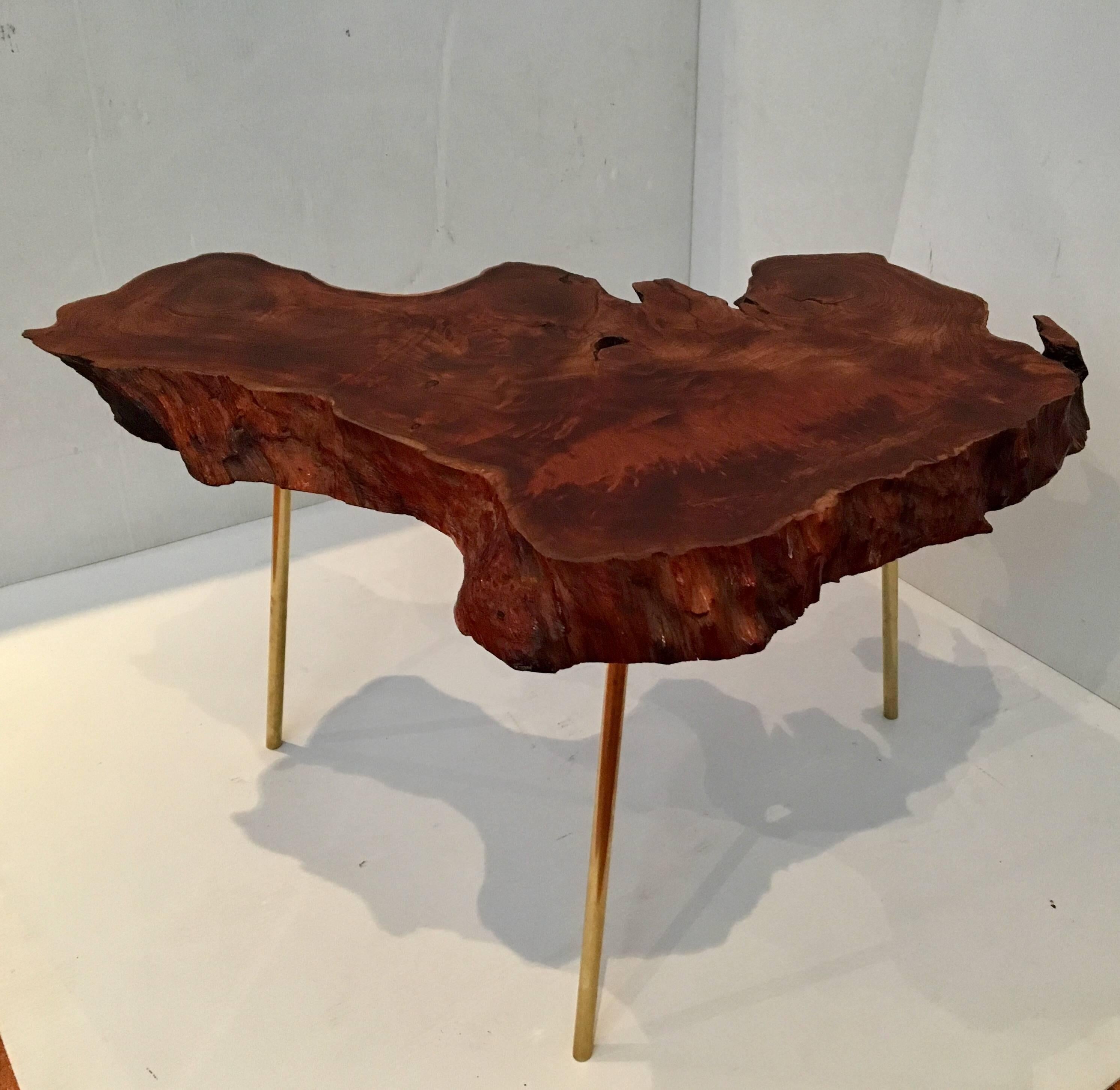 Biomorphic free-form coffee or cocktail table, in the style of Carl Auböck, 2.75" thick solid wood slab of redwood, sitting on three solid brass tubular legs, the top has been refinished and oiled, left the natural finish and the legs have been