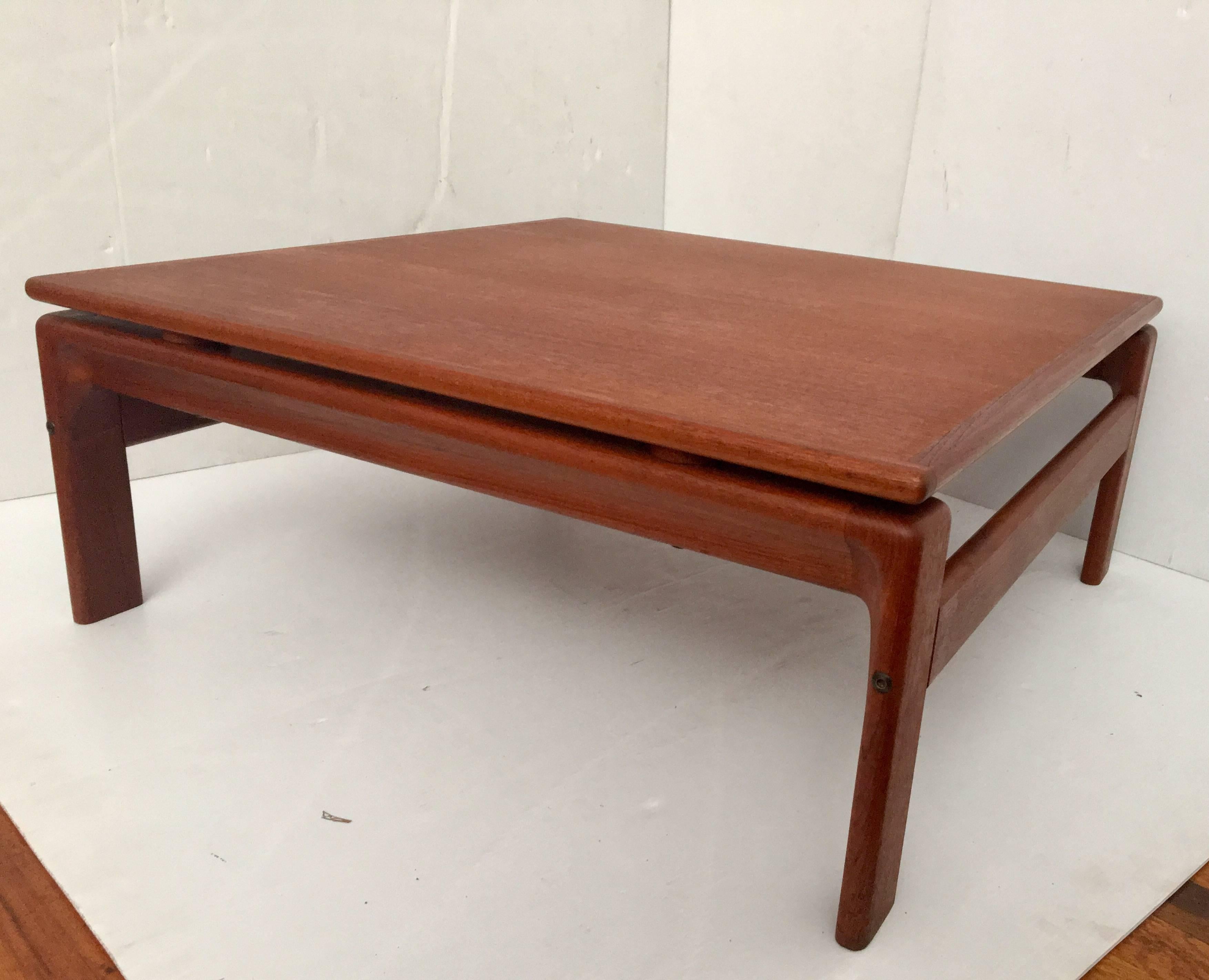 Simple elegant low coffee table, circa 1960s, Made by Komfort, in solid teak legs, totally restored and refinish with hand rubbed teak oil finish, nice condition solid and sturdy a rare piece to find. Nice sculpted leg base.