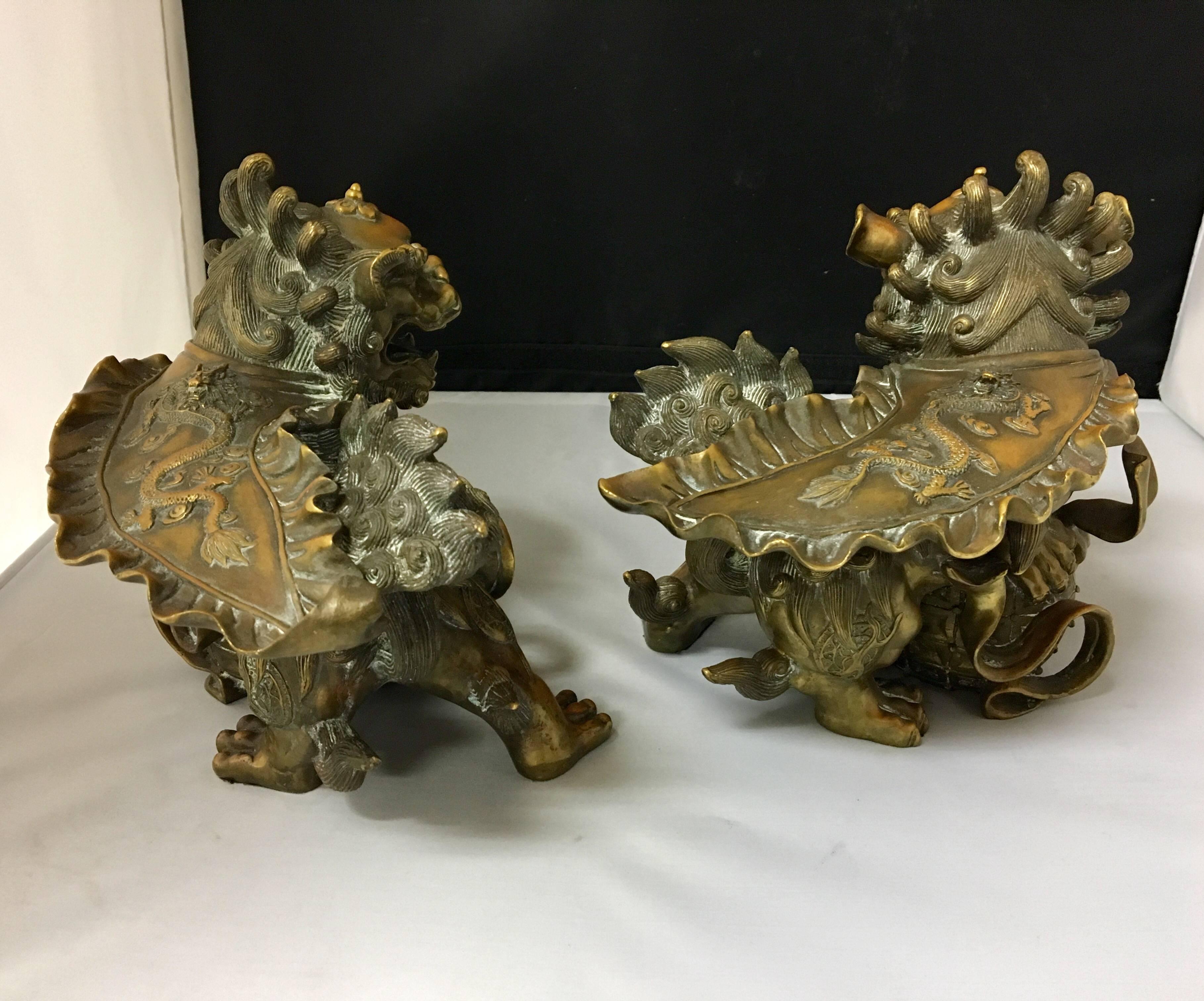Incredibly unique pair of heavy bronze foo dogs or lions that can be used as decorative accents or bookends. Amazing detail and a gorgeous nice patina.