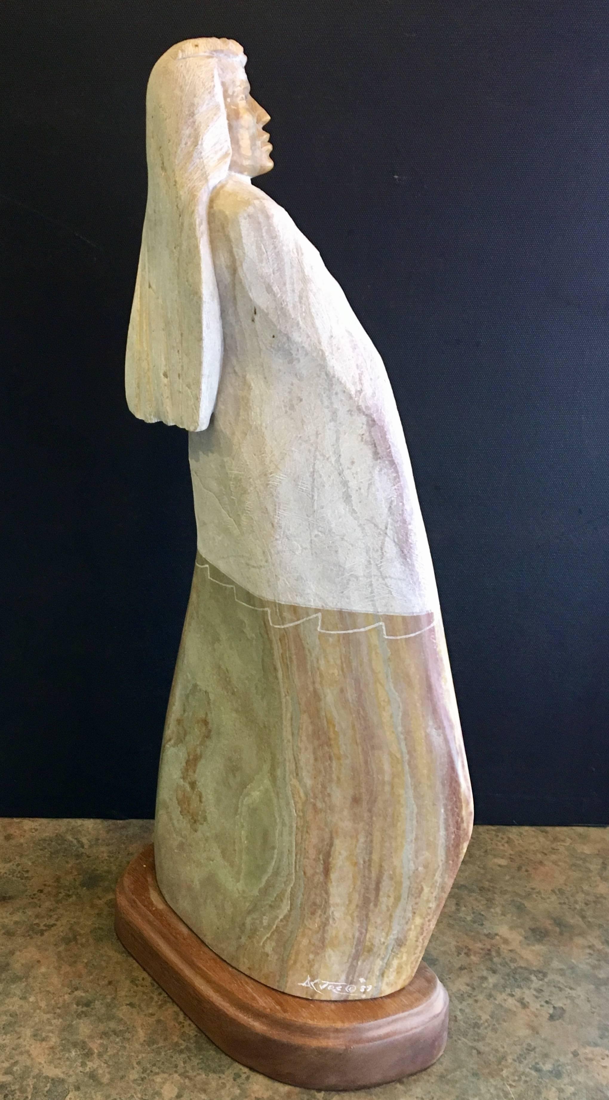 Impressive sculpture of an American Indian carved from Utah alabaster by acclaimed Ute/Navajo artist Oreland C. Joe. The piece is absolutely stunning and would make an excellent addition to any collection. The statue is 25" tall and sits on a
