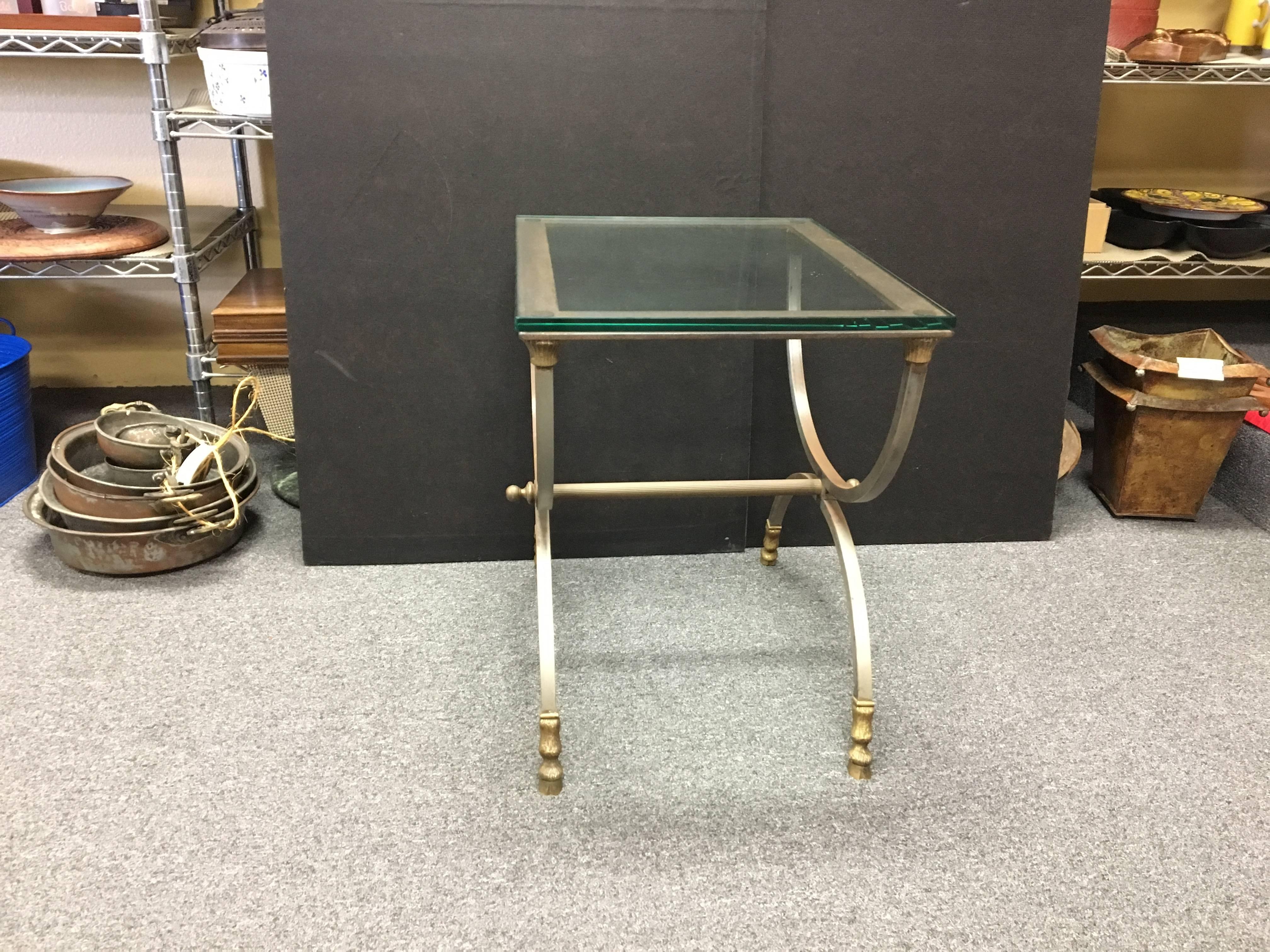 Elegant Italian table by Maison Jansen circa 1960s. Stamped under the brass feet "Made in Italy". Polished stainless steel with brass feet and a thick glass tabletop. Very nice original condition.