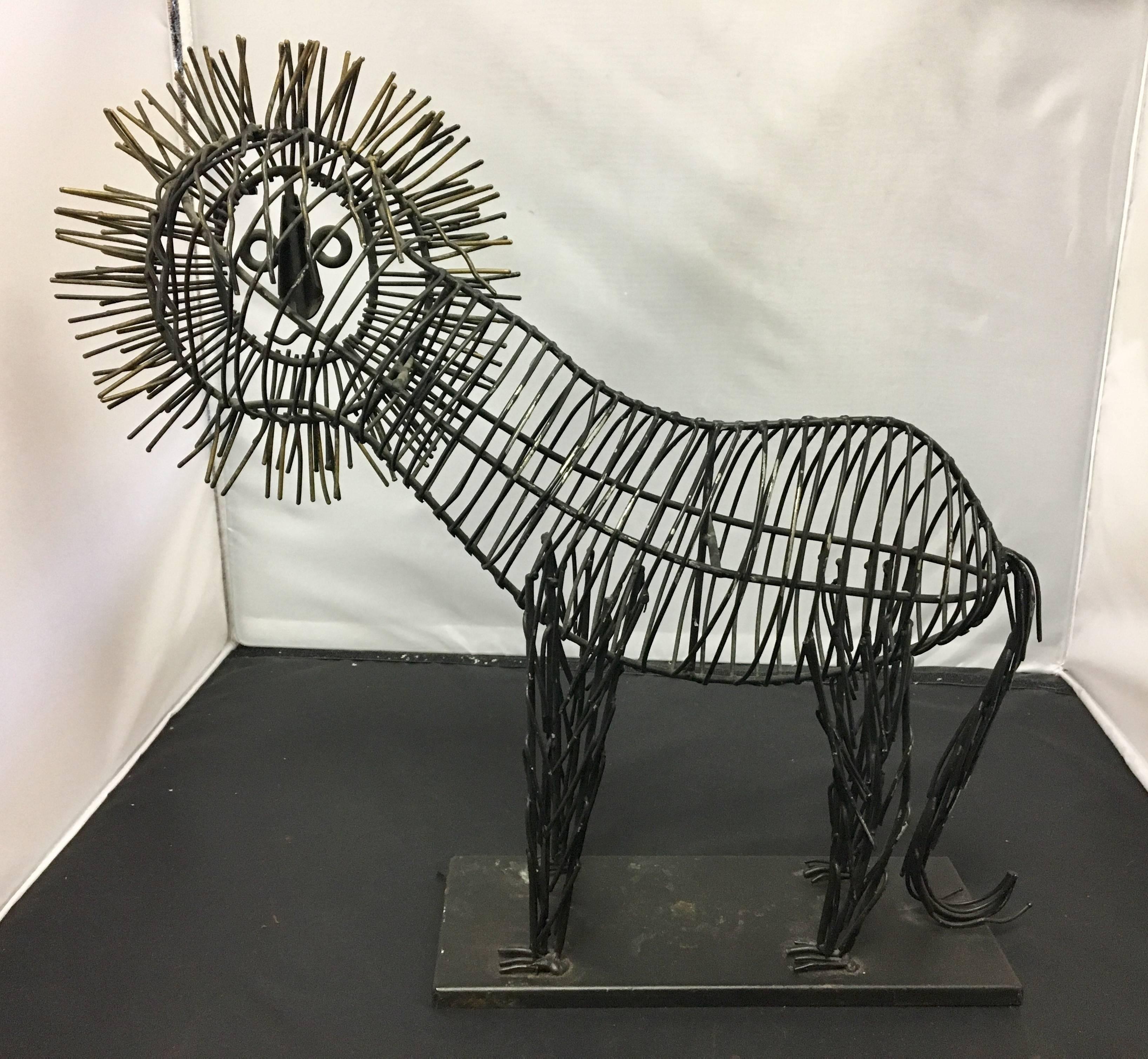 Fun, metal wire sculpture of a male lion sitting on a black metal base. The body is black metal wire and the mane is tinted in gold. The piece is unsigned but in the style of C. Jere, circa 1980s.