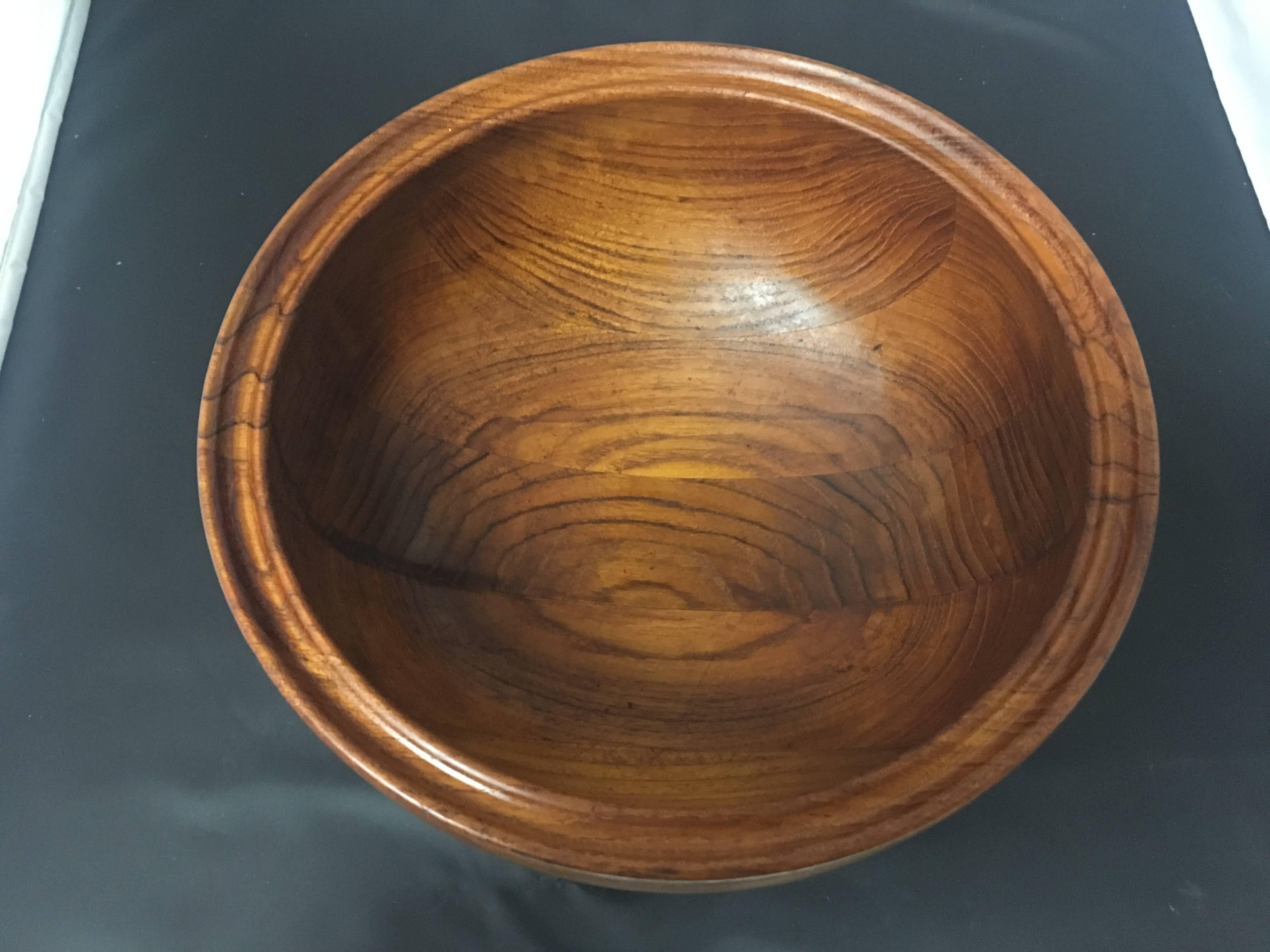 Beautiful solid turned teak serving or salad bowl designed by Henning Koppel for Georg Jensen. This gorgeous vintage bowl has a footed base and an undulating form with a rimmed edge. Stamped and signed at the bottom.  #143