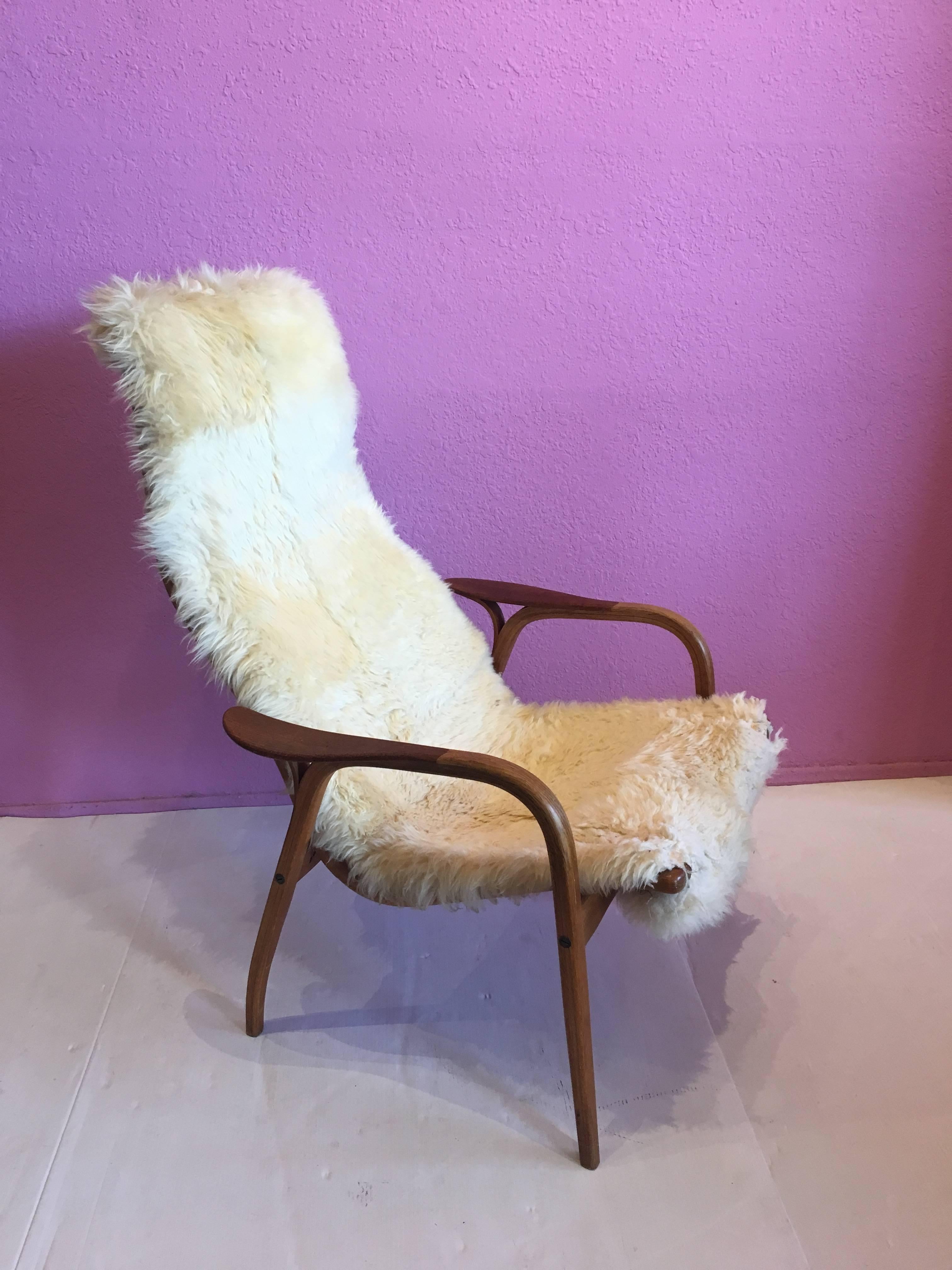 Nice lounge chair and ottoman by Yngve Ekstrom for Swedese, circa 1960s. In sheepskin with teak arms, the chair has its original finish and is very clean. From original owner, non-smoking home.
