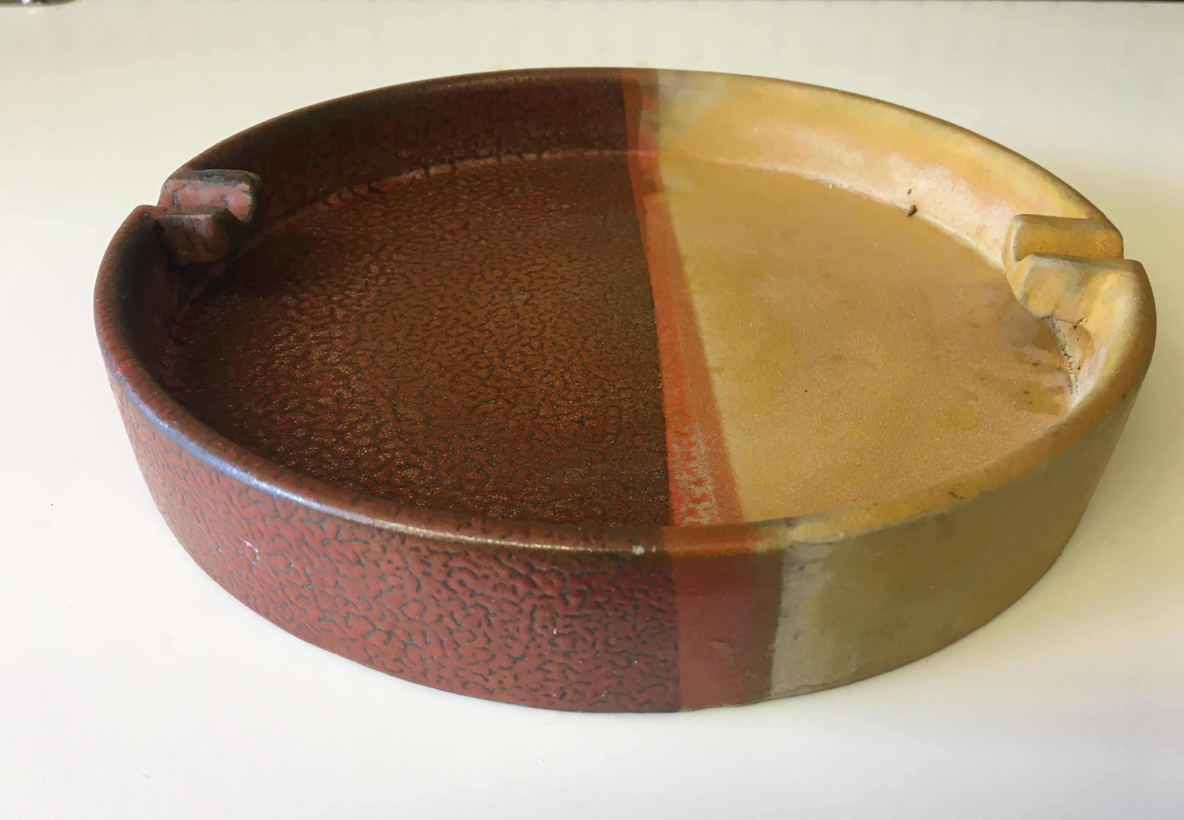 Beautiful orange, brown and mustard combination colors and glaze on this unique large ashtray. Made in Italy, circa 1950s by Bitossi for Raymor Imports.