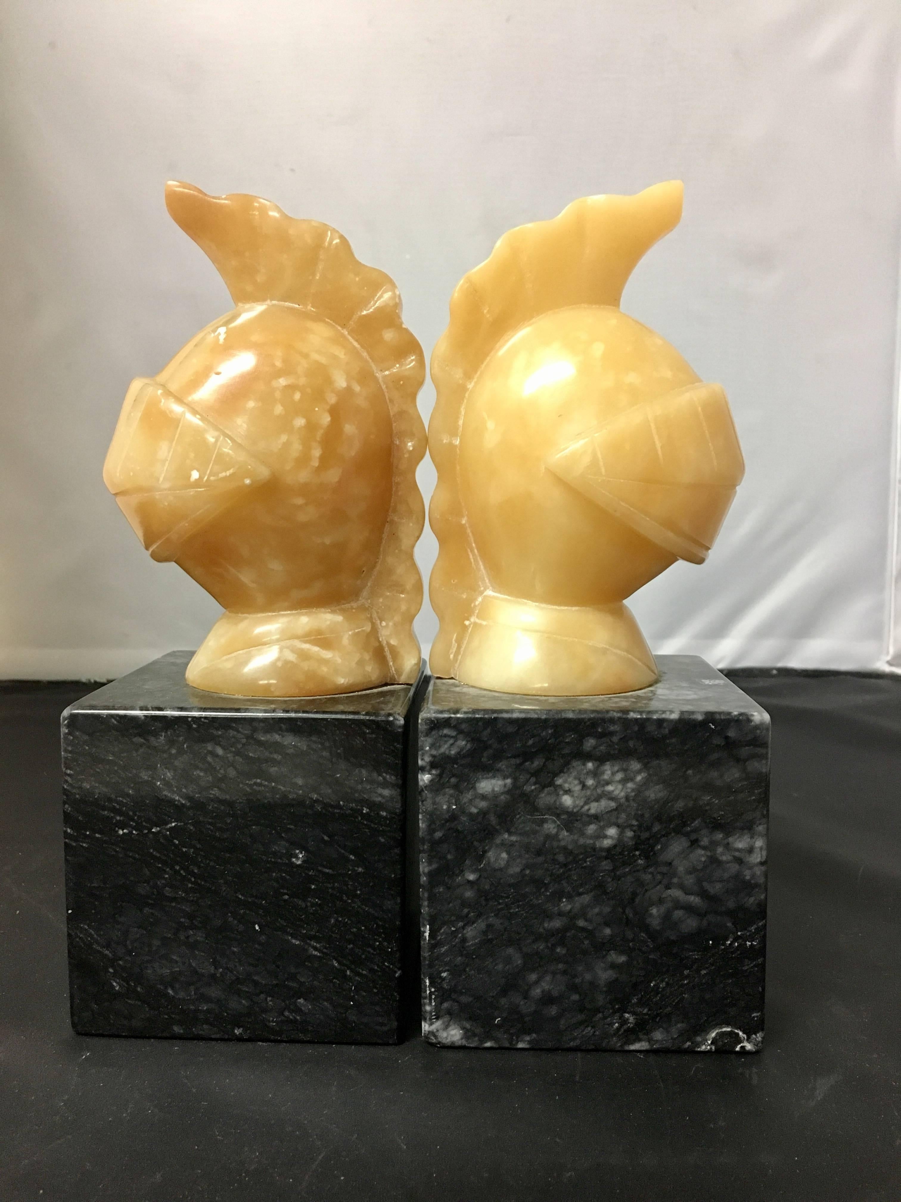 Elegant pair of Trojan helmet bookends made of cream alabaster on a solid black marble base, circa 1960s.