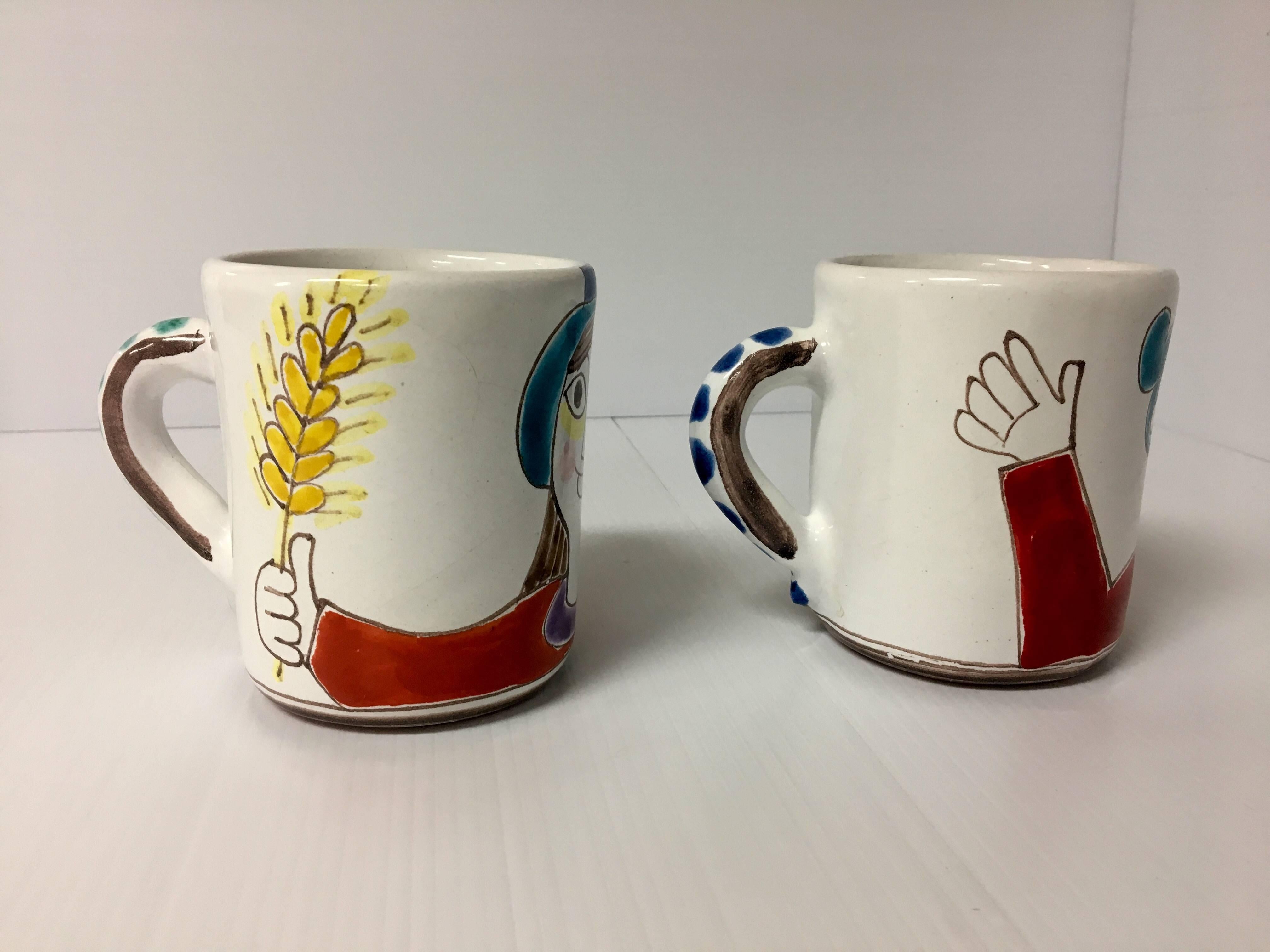 Nice pair of hand-painted ceramic mugs by Italian Artist Giovanni Desimone. 
Unique, hard to find "his and hers" pair in excellent condition.