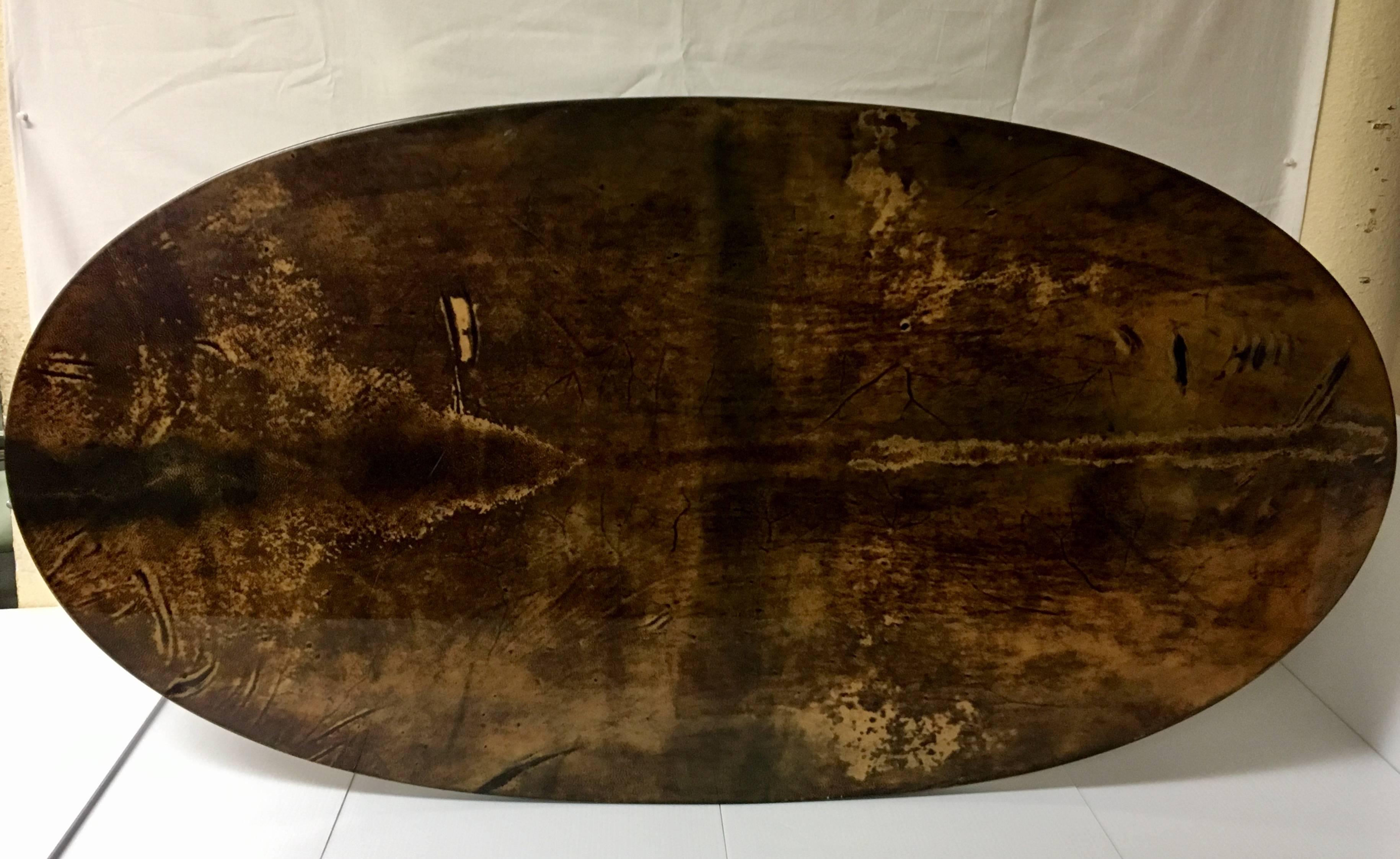 Elegant coffee table designed by Aldo Tura, circa 1960s. The tabletop is a dark goatskin wrap with regency style brass legs and is in very nice vintage condition.