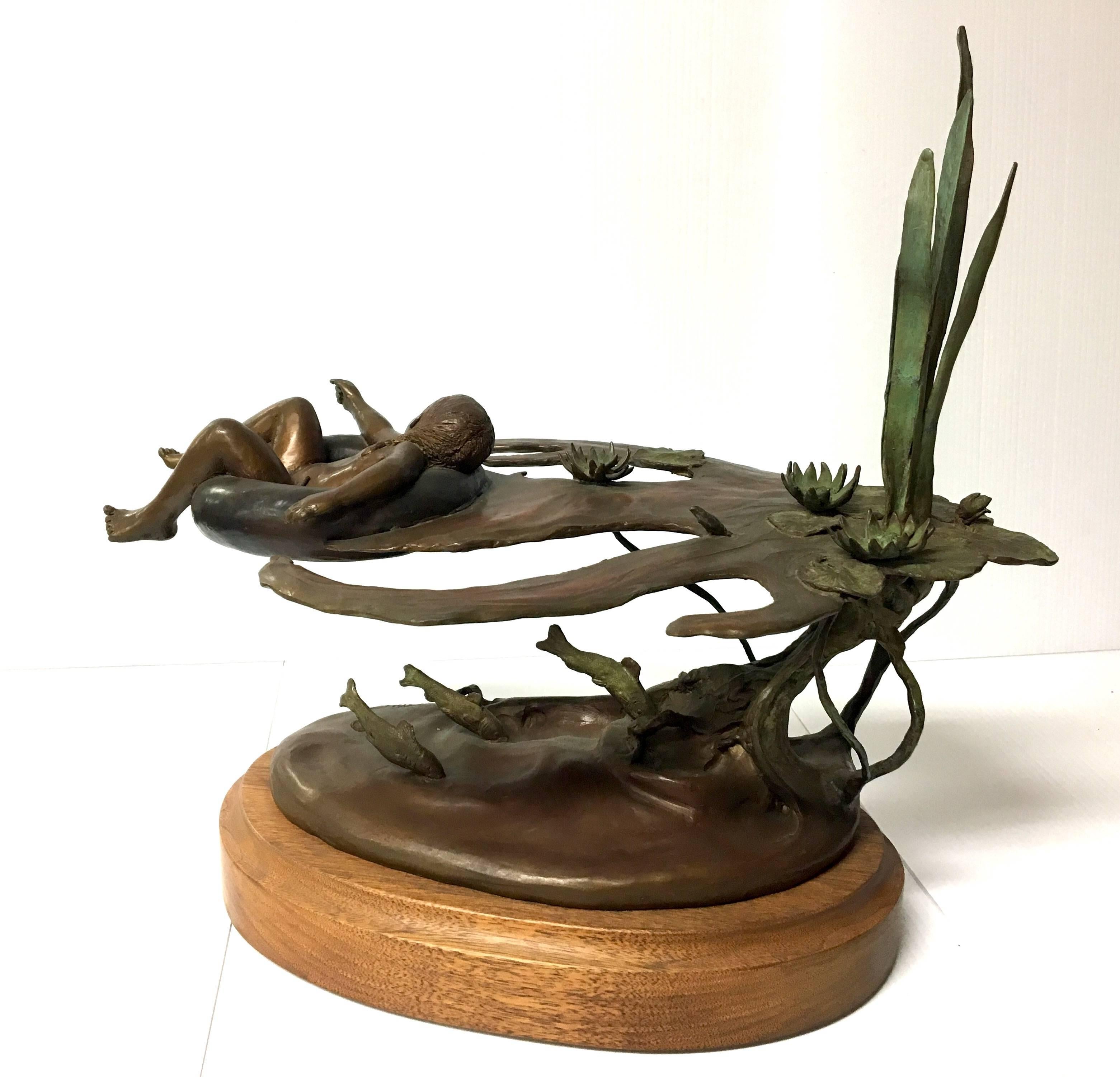 Beautiful sculpture of a little girl on an inner tube floating on the river by listed Sedona artist Joyce Killebrew, circa 1980s. This exquisite piece, entitled "Katy" mounted in a rotatory oak base, signed and numbered 4/20.