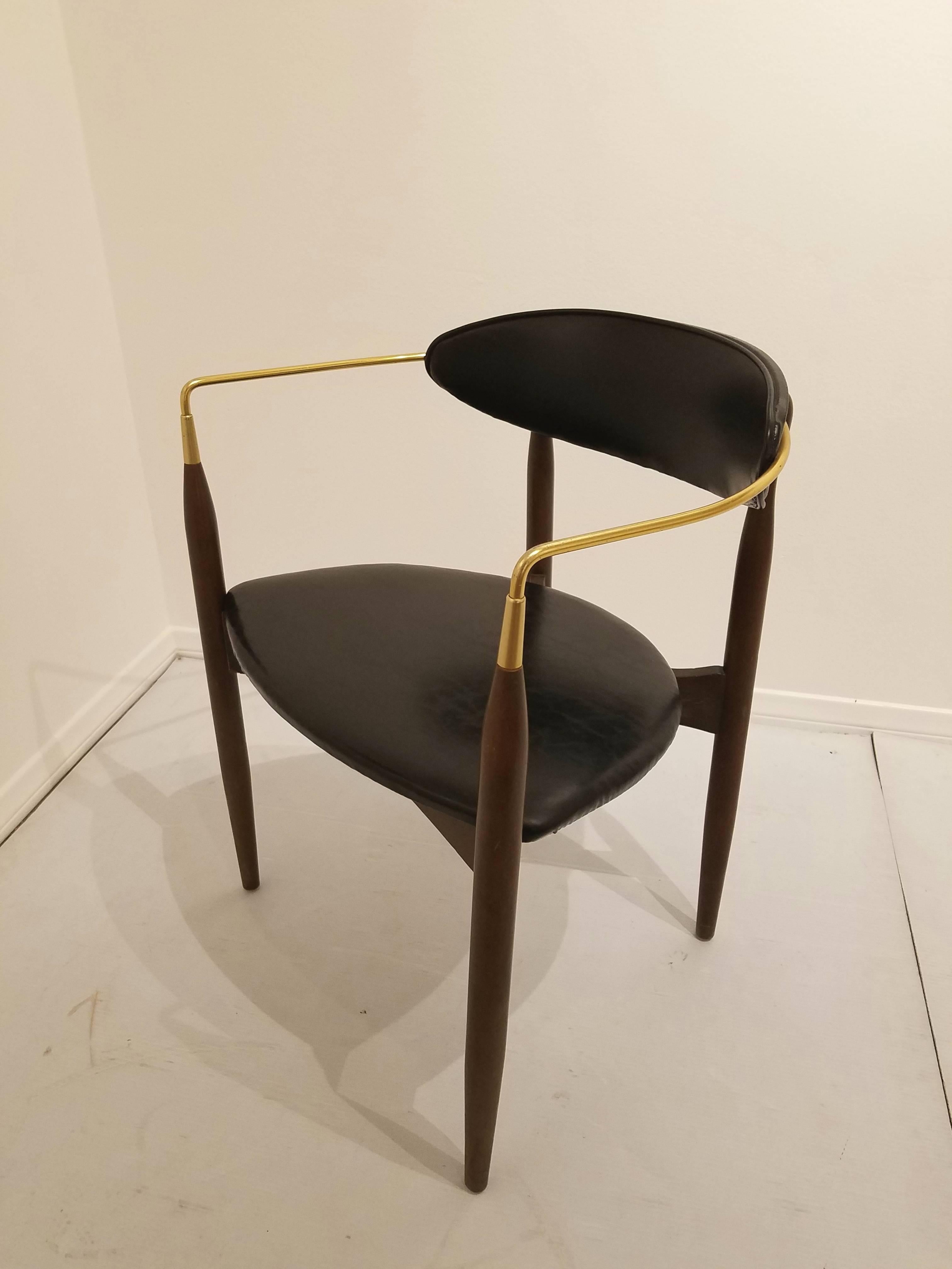 Classic and hard to find Viscount chair designed by Dan Johnson, circa 1950s. The brass tubing has been freshly polished and is mounted on solid walnut stain wood frame with black Naugahyde upholstered seat and back. In original finish and very good