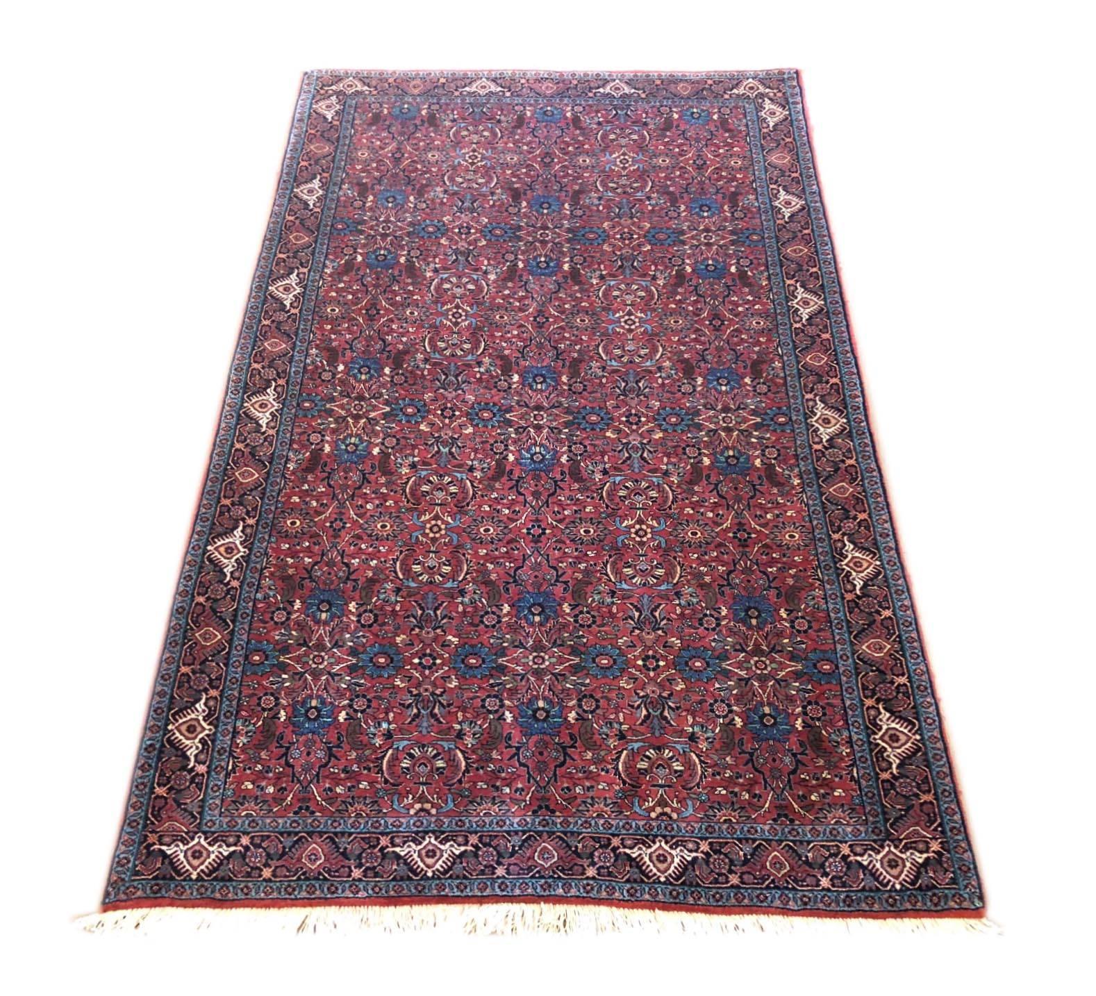 This piece is a handmade Persian Bijar rug. The pile is wool and silk with cotton foundation. This rug has an excellent condition with red, cream and blue color combination. Bijar rugs are well-known for their craftsmanship and design. The heavy