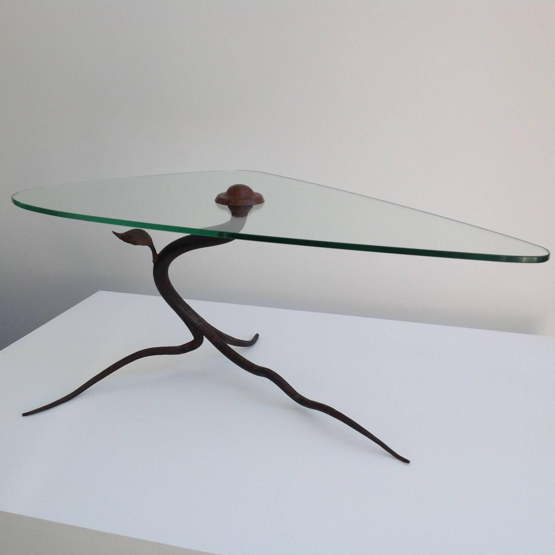 This is a very rare coffee table like a tree.
The structure is wrought iron with one small leaf in brass.
The glass top has a small hole through which is screwed a large round copper bolt.
See pictures, . . .

More pictures and with a higher