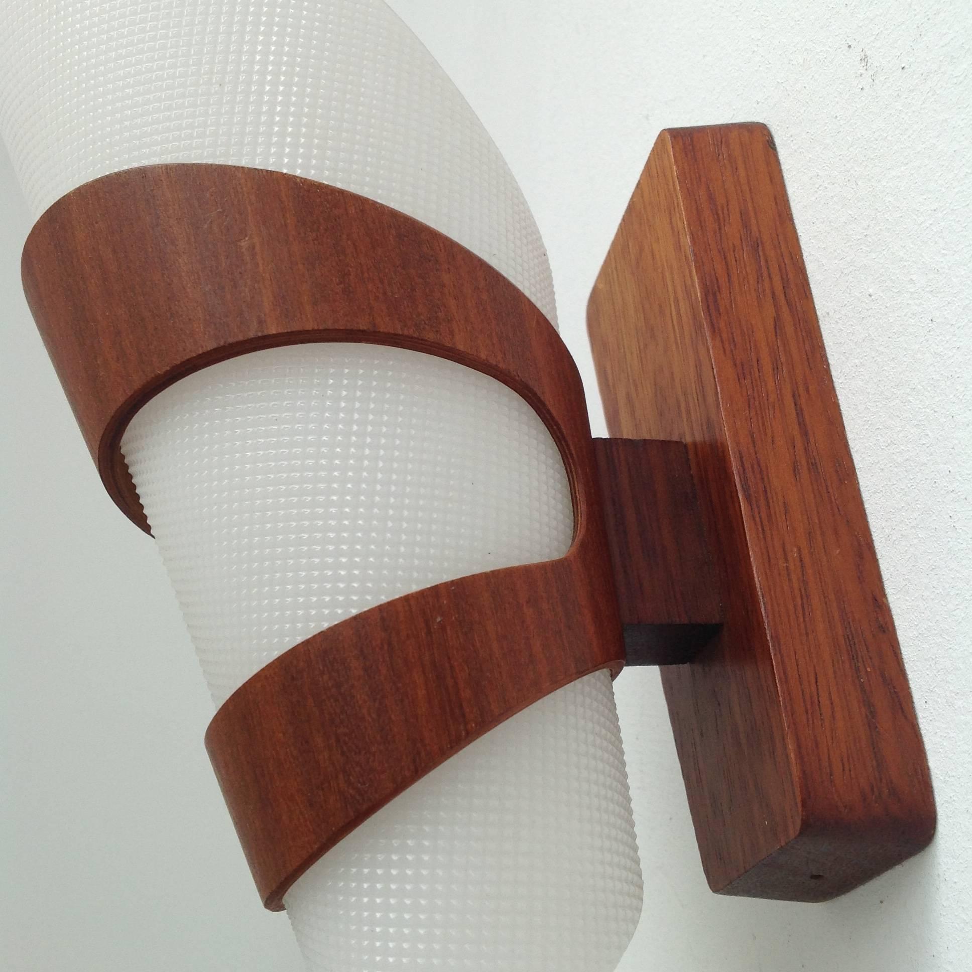 Beautiful handmade wall lamps from solid teak and plywood.
The cone lamp shades are made of engraved plexiglass.
The two original E14 sockets are completely checked and the wiring is replaced and ok for the US.

More pictures and with a higher