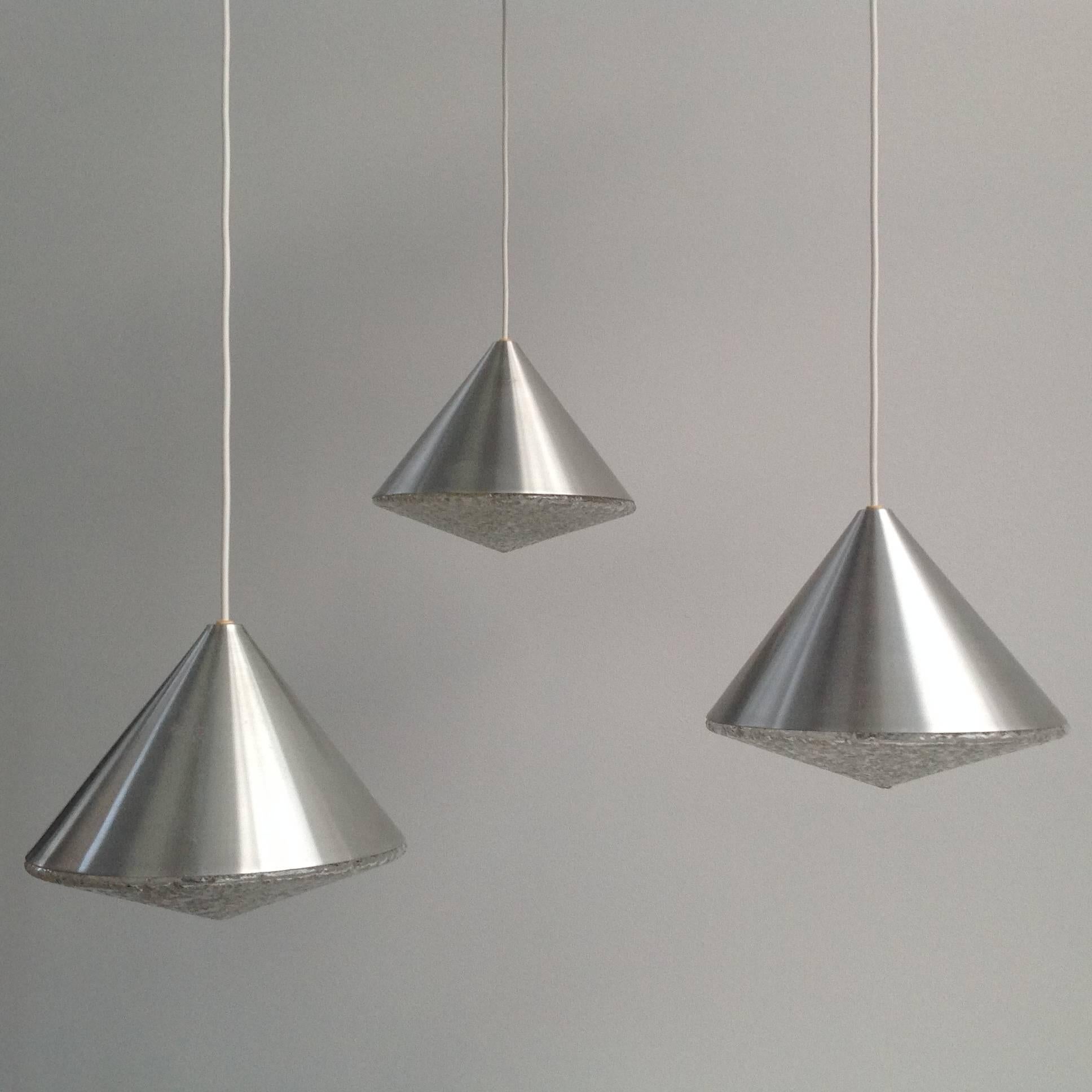 Three conical glass shades integrated with small pieces of glass, covered with brushed aluminum hood. Each glass shade features an outstanding design with amazing effect. Glass objects vary in different heights. The length of the cable can be