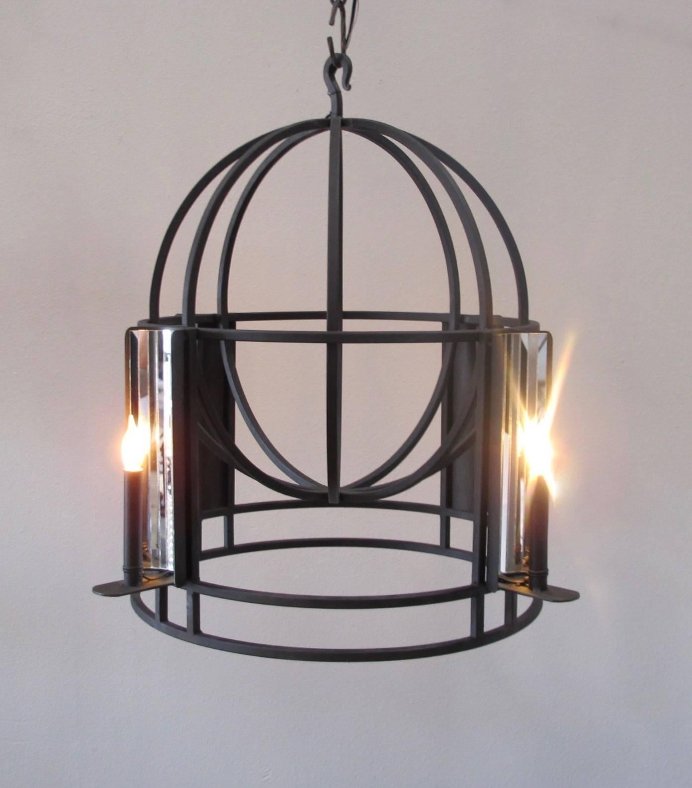 Custom iron chandelier with hand cut mirrored panels. This chandelier has a hand-painted aged black finish and four candelabra base bulbs. The light reflects beautifully in the mirrored panels and the black finish gives a nice contrast to the
