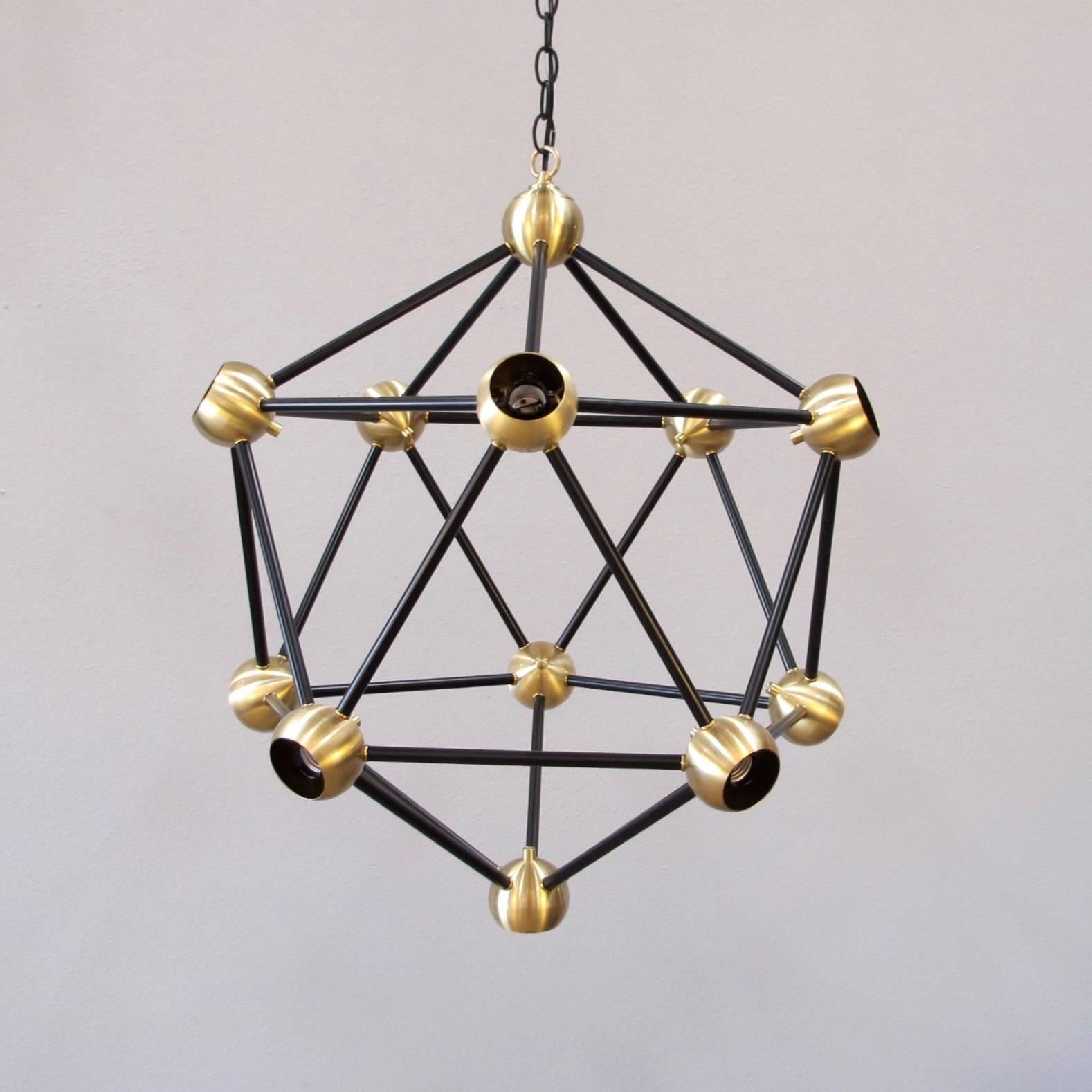 Striking black and brass large pendant light. 11 lights, medium base sockets up to 40 watts/socket. Works great with large round light bulbs for a dramatic effect. Bulbs not included. Can be hung on rod or chain. Custom sizes and finishes available.