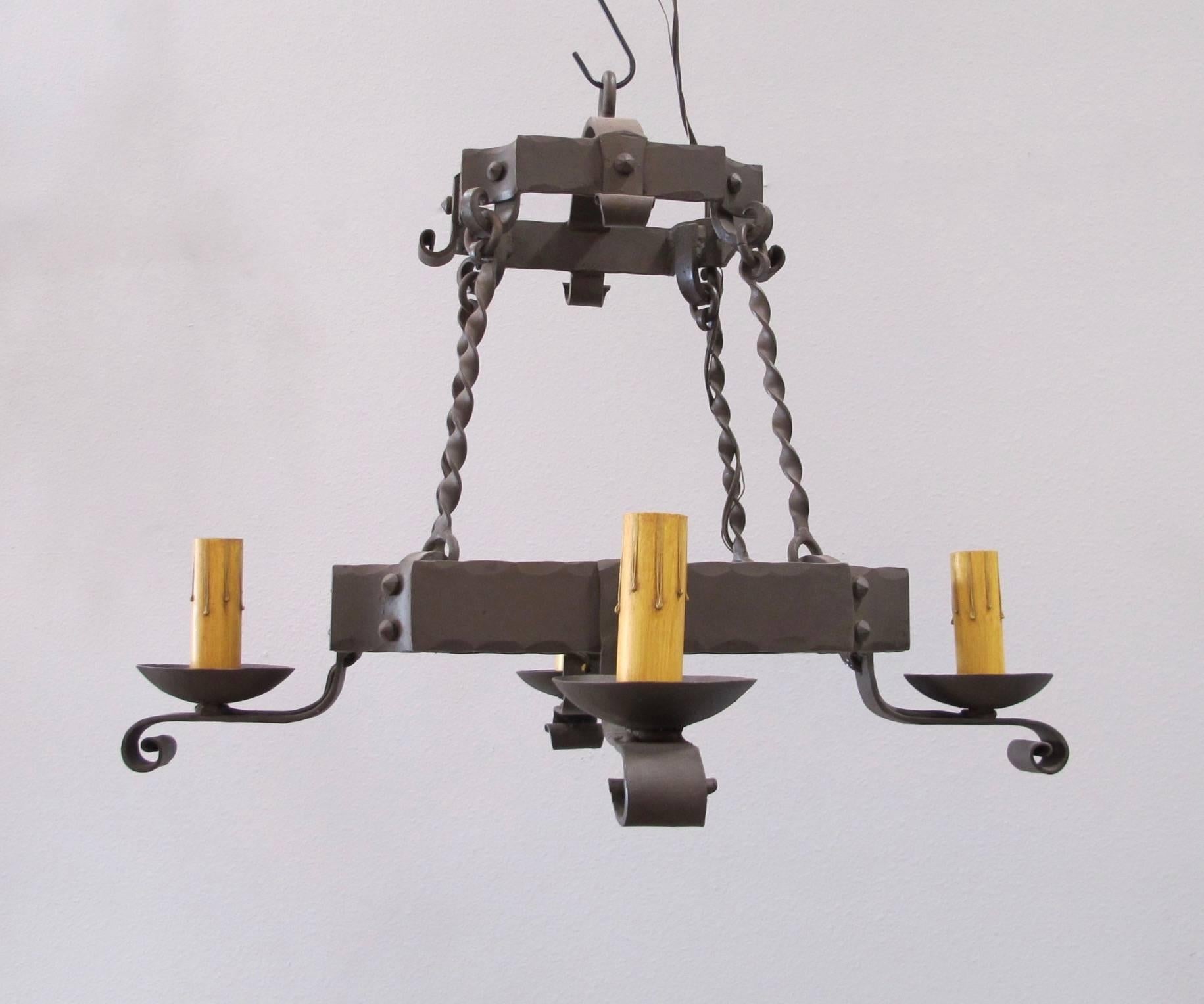 Hand-forged small iron chandelier with four lights. Medium base bulb up to 60 watts/socket. Aged iron finish. UL Listed, chain and canopy included. Courtesy to the trade.