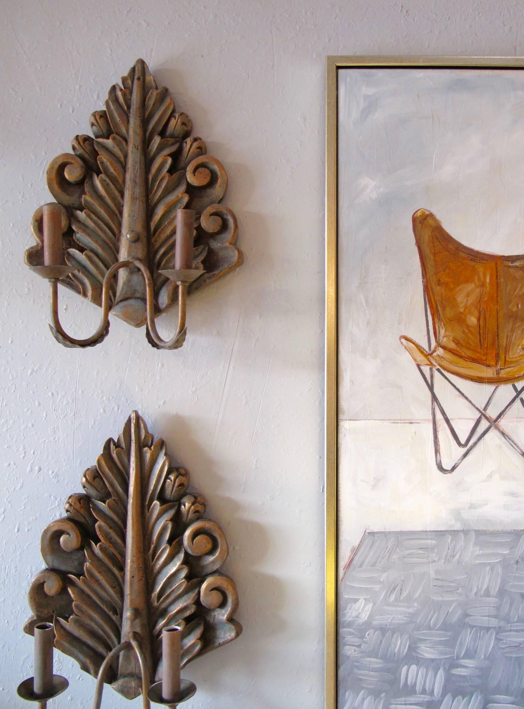 Pair of double arm sconces created with found vintage carved wood fragment and new iron arms. Hand painted copper and Verde finish. Candelabra base bulbs up to 60 watts/socket. UL approved. Courtesy to the trade.