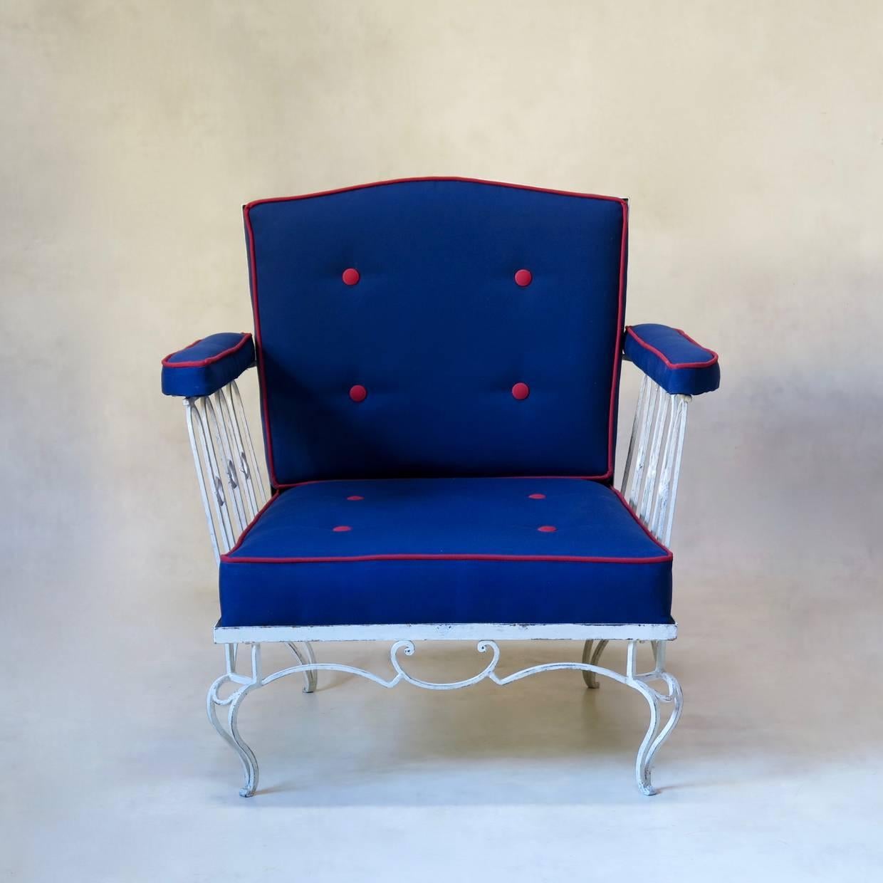 Elegant pair of low painted iron armchairs, in the style of René Prou, René Drouet, Jean-Charles Moreux... Raised on short cabriole legs. Slight moustache-shaped crest. Upholstered in outdoor fabric.