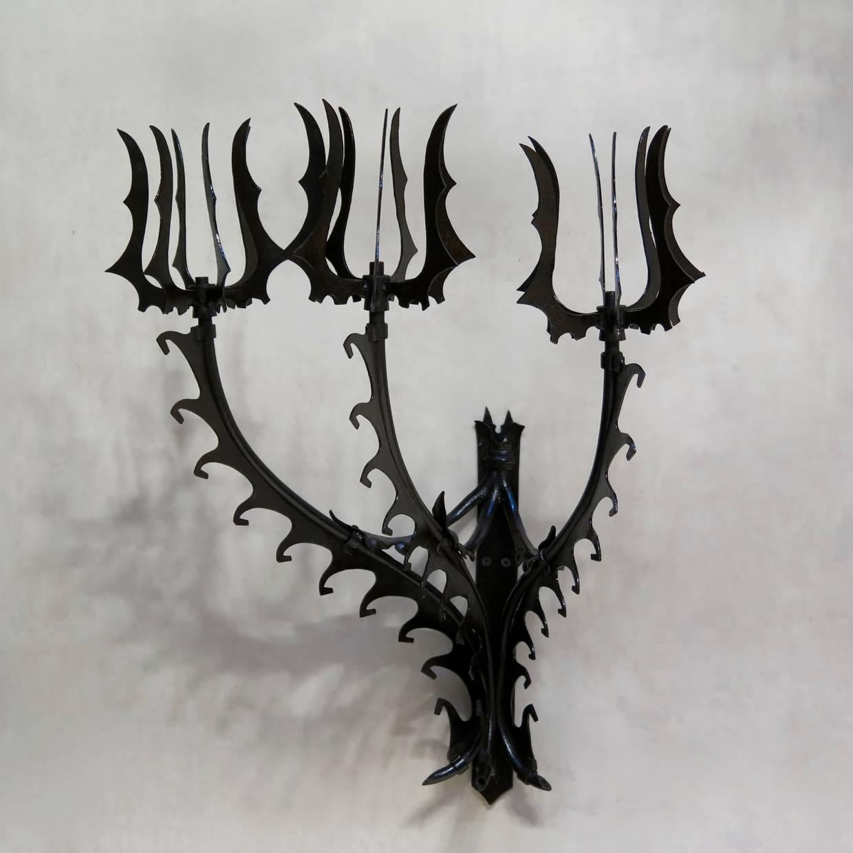 Large and unusual set of four Gothic inspired sconces displaying striking ironwork. Each sconce has three arms. Can be wired.
