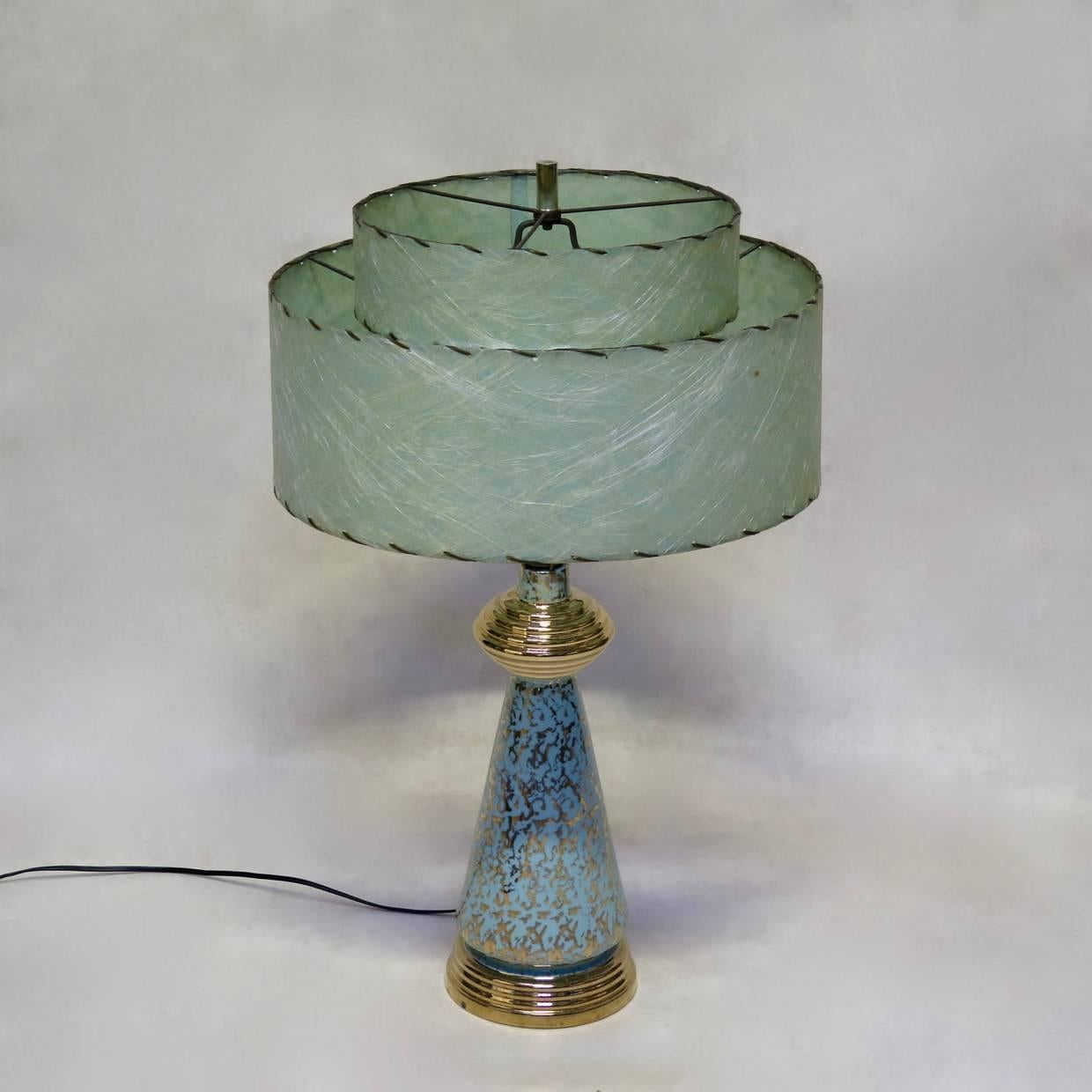 Delightful and rather crazy pair of tall table lamps with a porcelain base, with light duck-egg blue glaze, speckled with gold. The lovely (original), double-tiered, pale green shades are of thick paper stitched onto wire frames and show Fine,