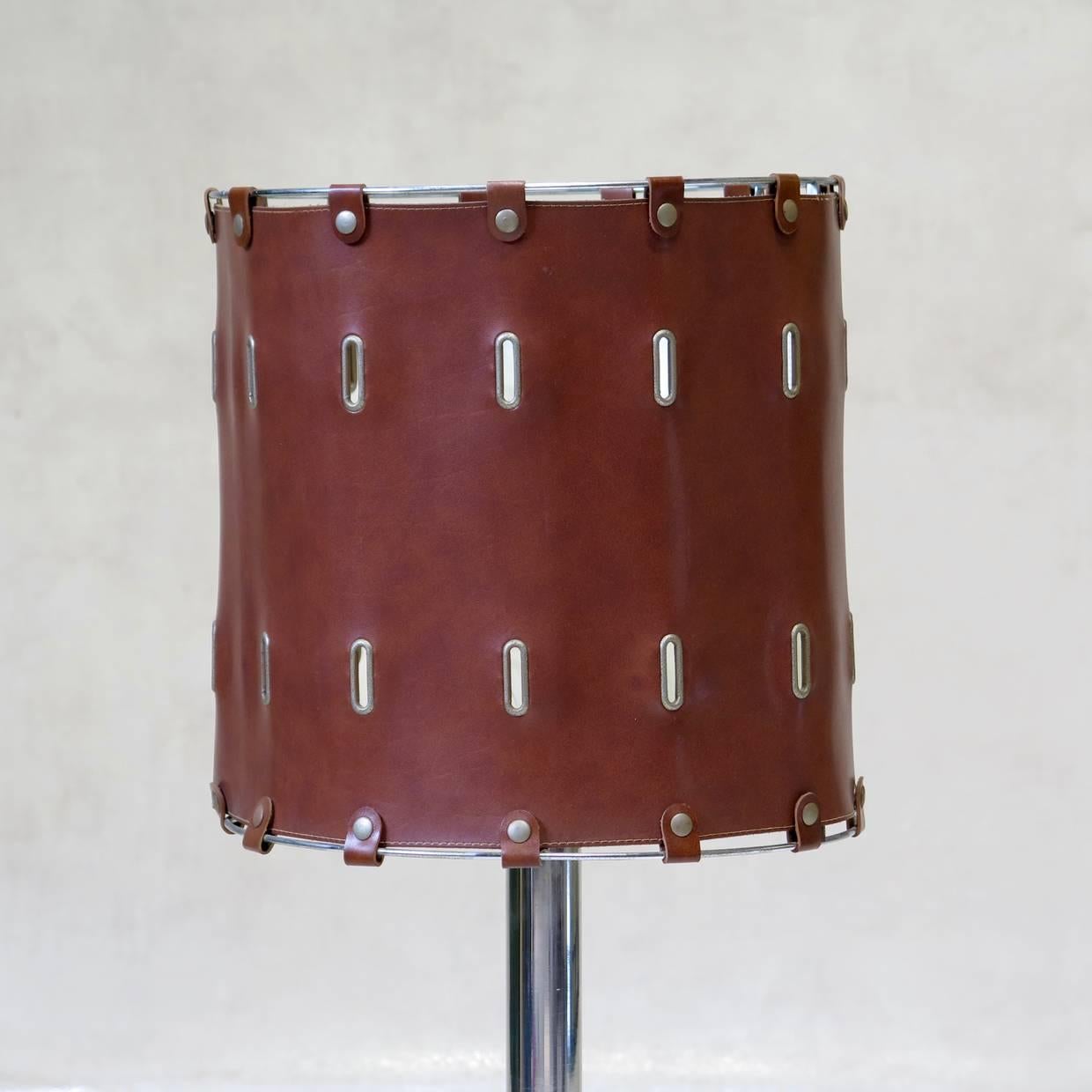 Well-made desk lamp with a chromed base and an imitation leather shade with oblong eyelets.