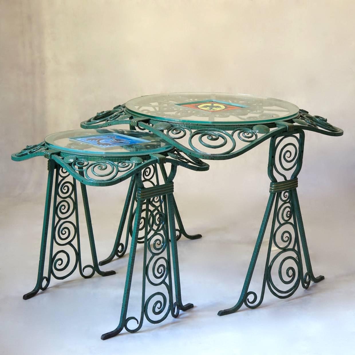 Set comprised of two side tables (one small, one large) and two tall columns, which could be adapted as floor lamps, or used as are.

Fashioned out of hammered wrought iron, painted sea green, with gold highlights. 

The tables have sloping