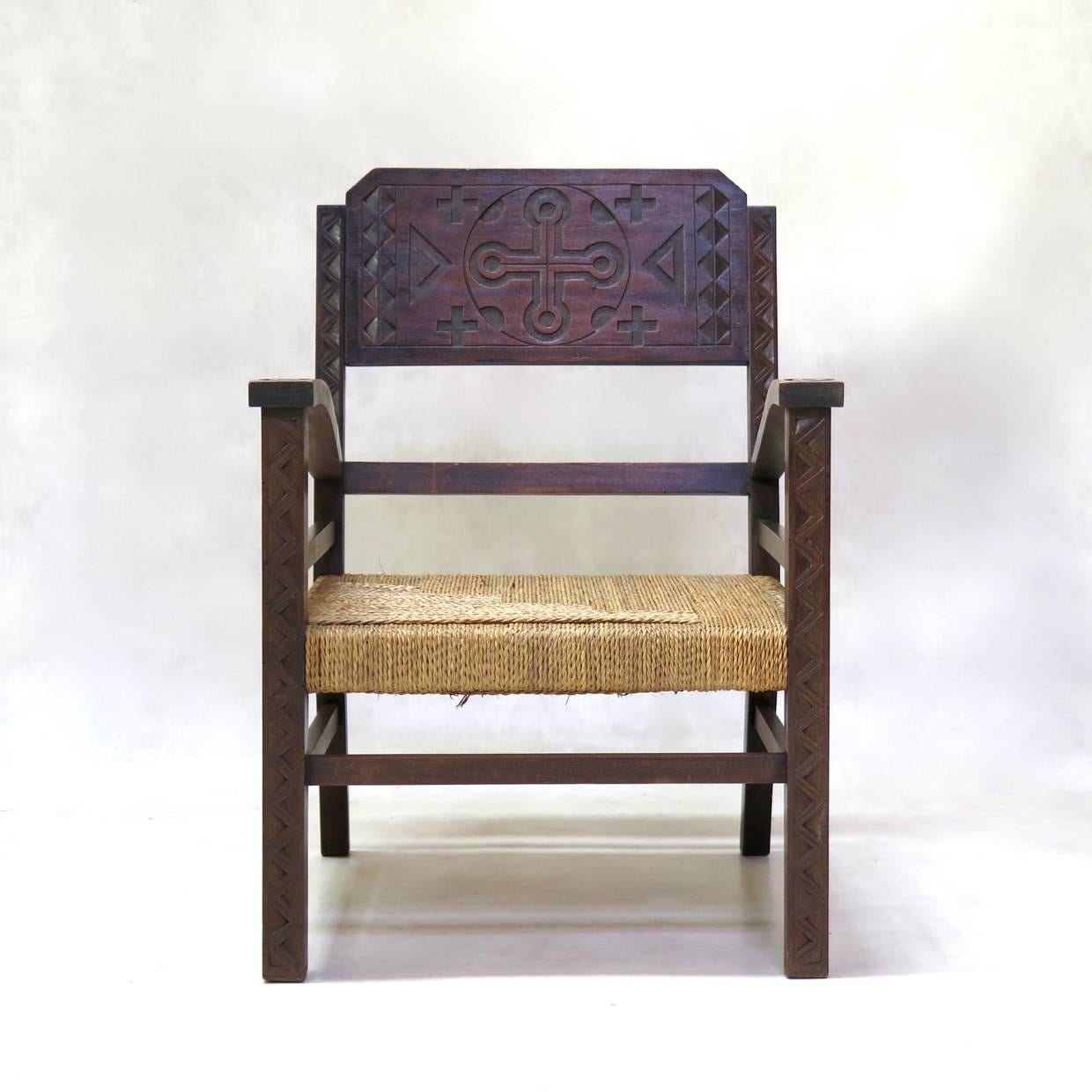 Handsome pair of armchairs, very much in the style of Francis Jourdain. The wood structure is carved with geometric, African-inspired motifs. The woven rush seats also have a nice geometric pattern.