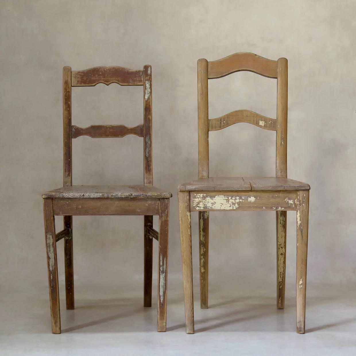Charming near-pair of rustic pine chairs, retaining traces of paint here and there. Large trapezoidal seats. Raised on sabre legs.
Priced individually.