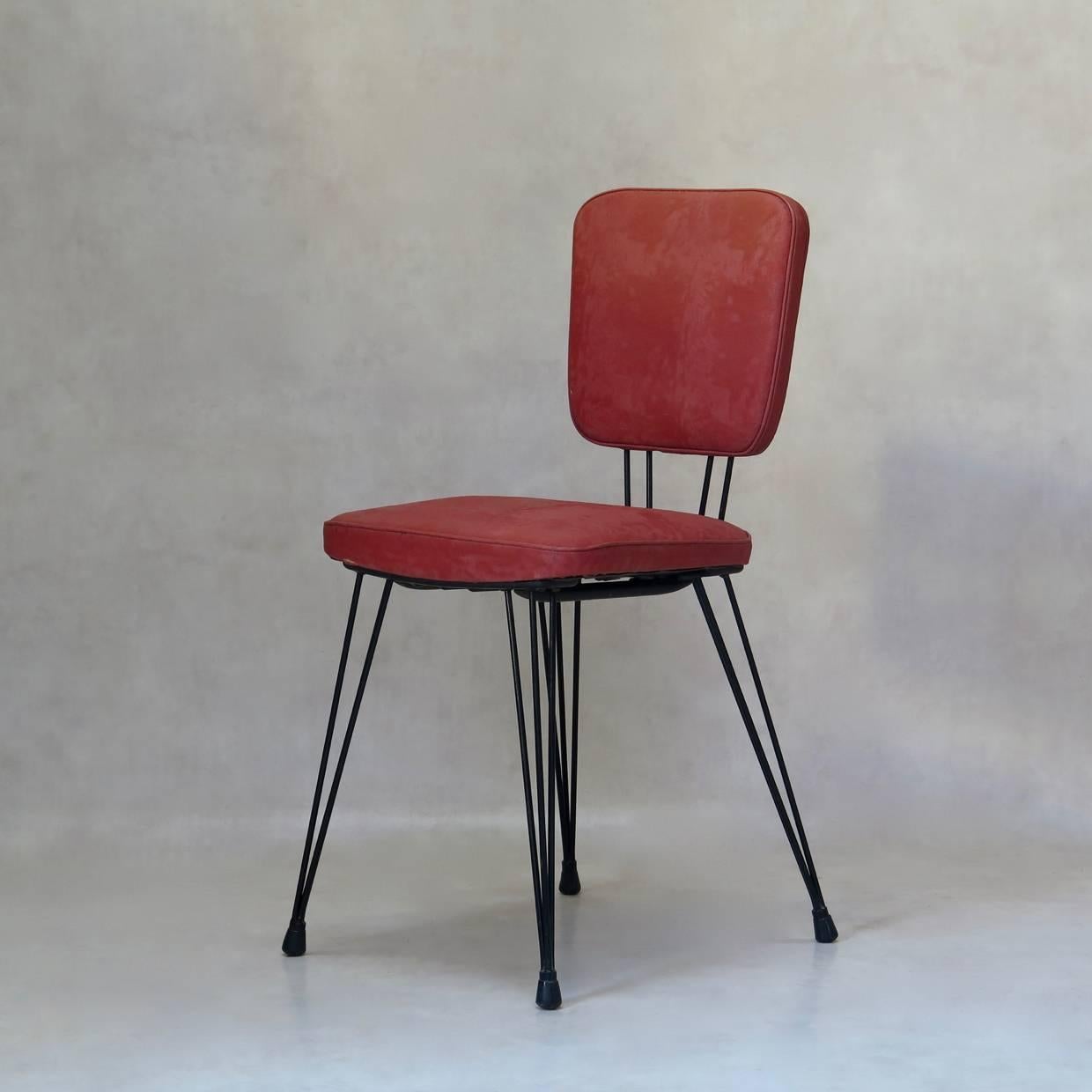 Fun and nicely-designed set of six dining chairs with an iron structure, painted black, and original plastic seats and backs with a moiré effect. Each leg in the splayed base is made up of three iron legs and tapers in towards the foot.